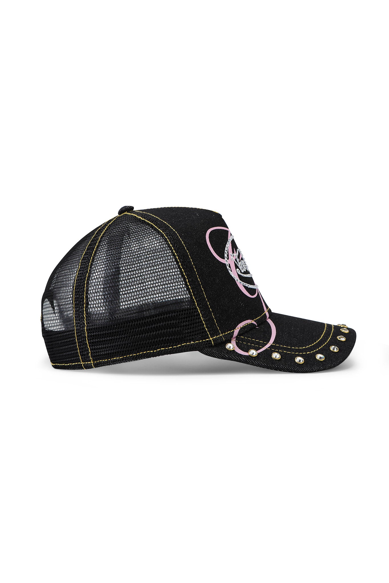 I.AM.GIA X VON DUTCH TRUCKER HAT - INDIGO DENIM features indigo denim panels, yellow stitching, silver studs on the brim, and a pink-and-white front graphic. Mesh back, curved bill, and iconic Von Dutch style complete the look.