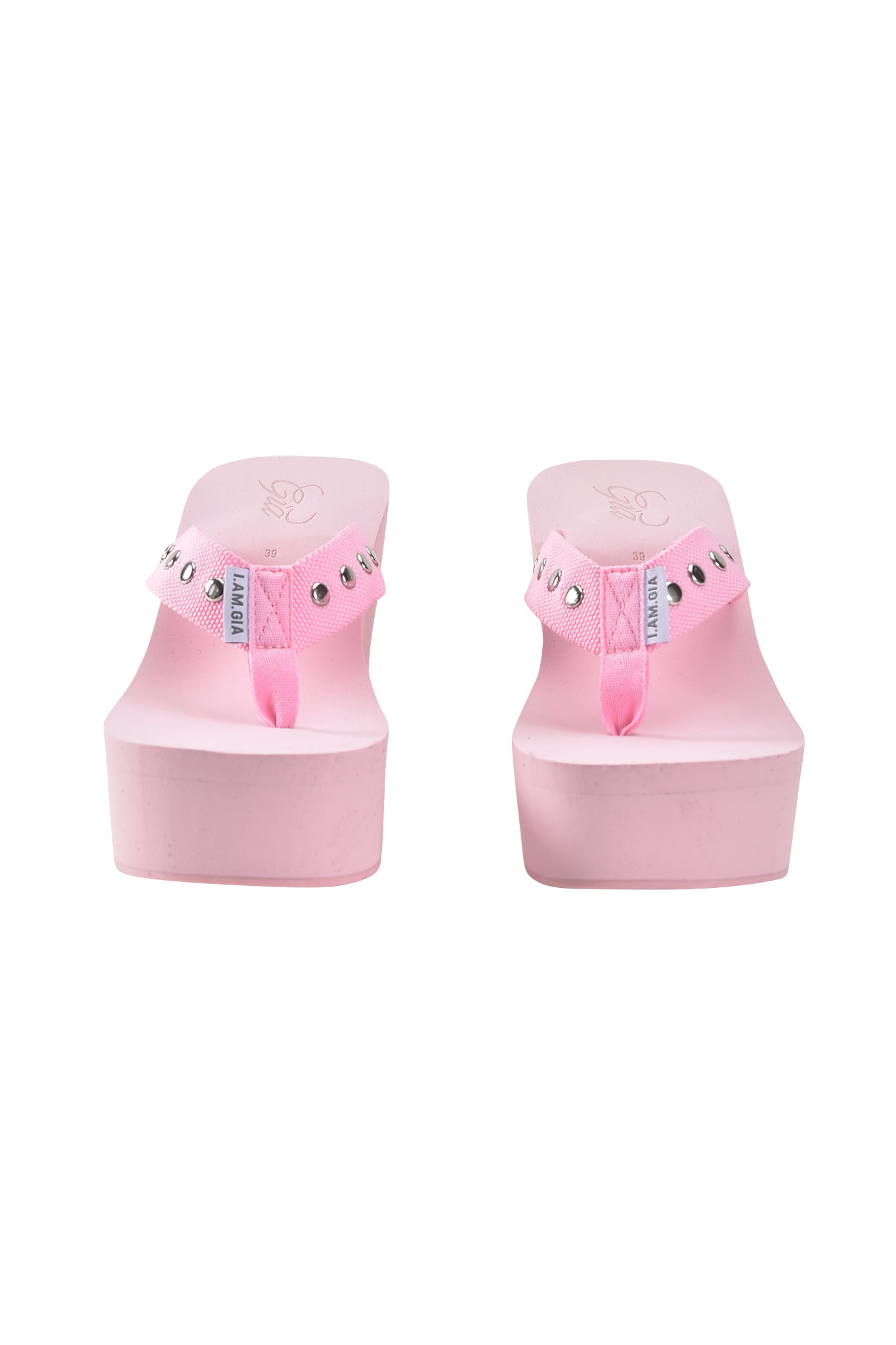 The I.AM.GIA SHELBY STUDDED FLIP FLOP 2.0 in baby pink features platform soles and studded strap embellishments, shown from the front against a white background.