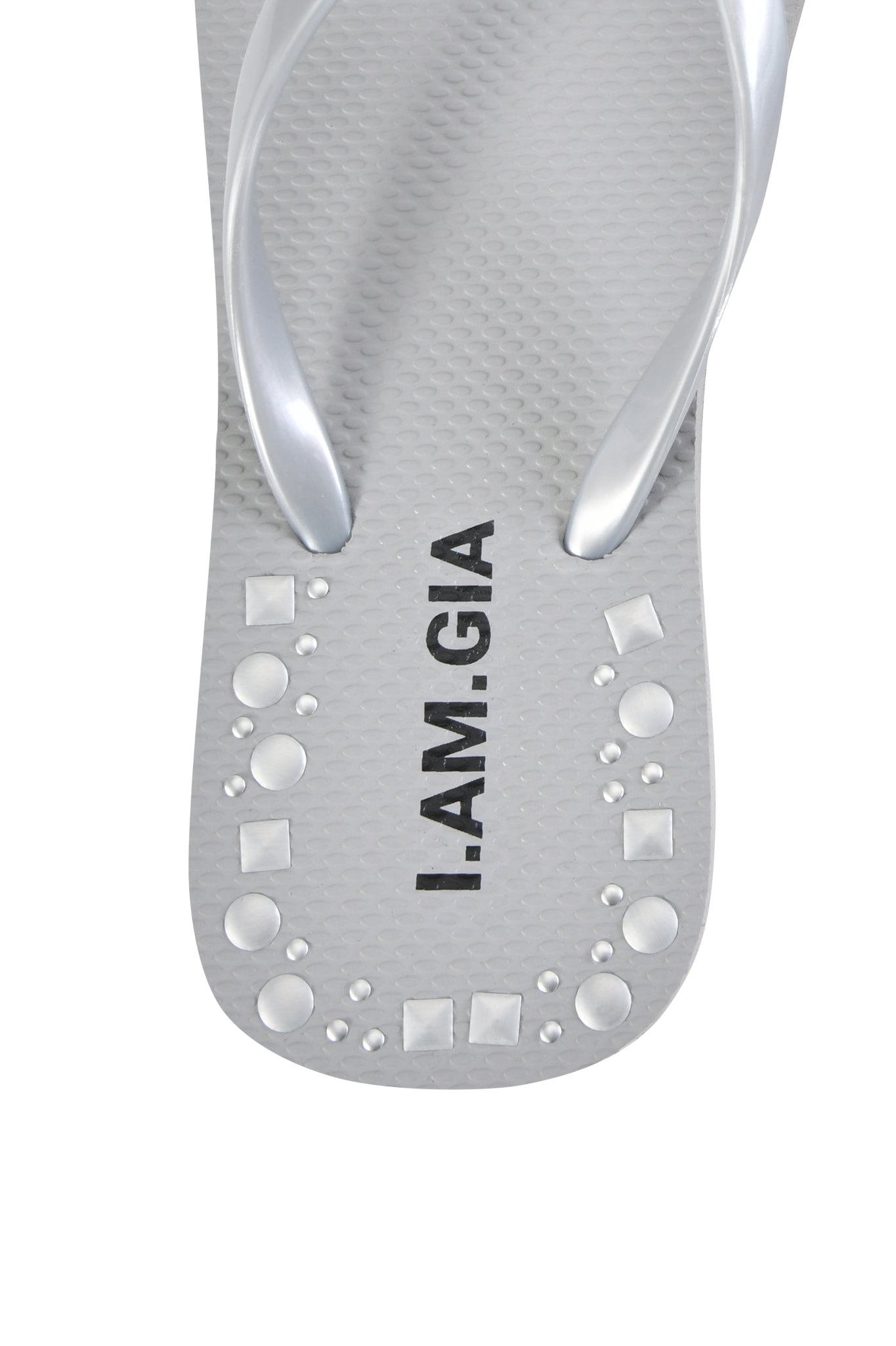 Close-up of the INKA STUDDED FLIP FLOP in silver by I.AM.GIA, featuring a gray studded design with raised circular and square shapes near the toe and "I.AM.GIA" printed in black on the comfortable sole.