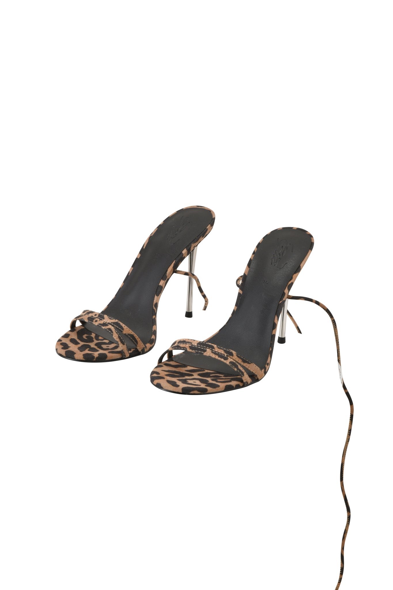 The I.AM.GIA SCARLETTE HEEL - LEOPARD features leopard print wraparound ankle straps, thin metal stiletto heels, and black soles, shown against a white background.