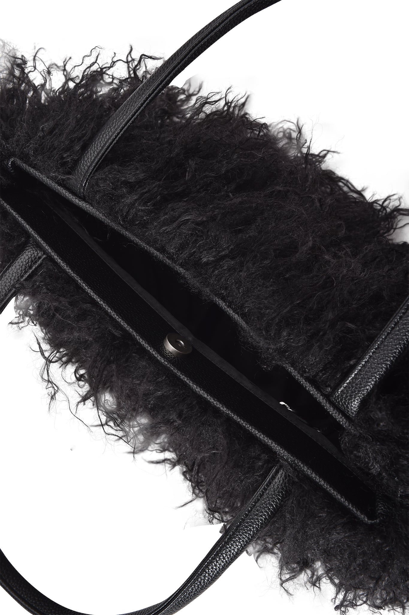 The I.AM.GIA PIXI FAUX FUR BAG - BLACK features a shaggy textured faux fur exterior, smooth faux leather handles, and a magnetic snap closure, shown partially open from above to reveal its interior.