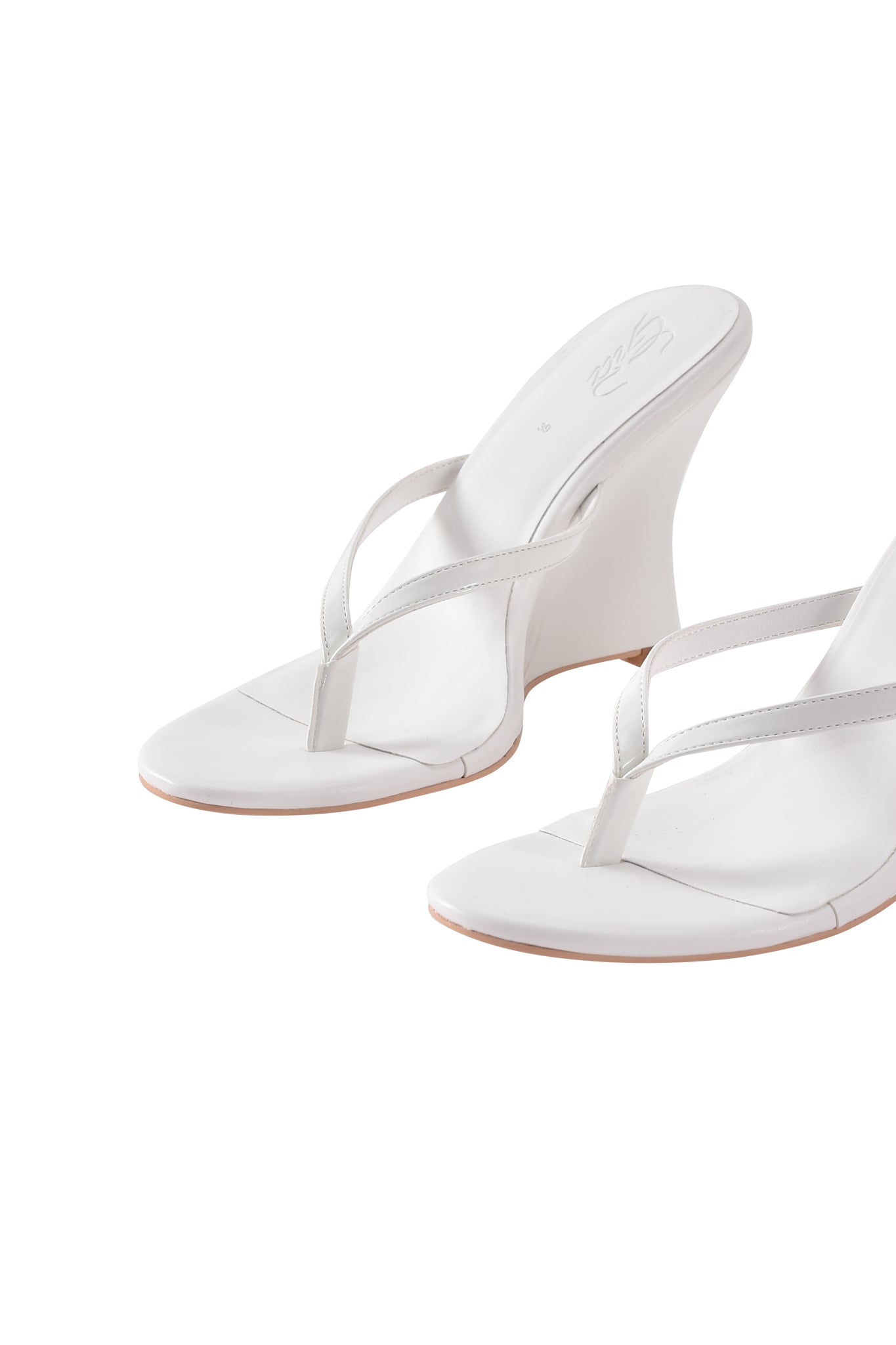 The VIKTORIA WEDGE HEEL - WHITE by I.AM.GIA features thin faux leather straps, open toes, and a wedge heel thong mule design, shown on a white background.