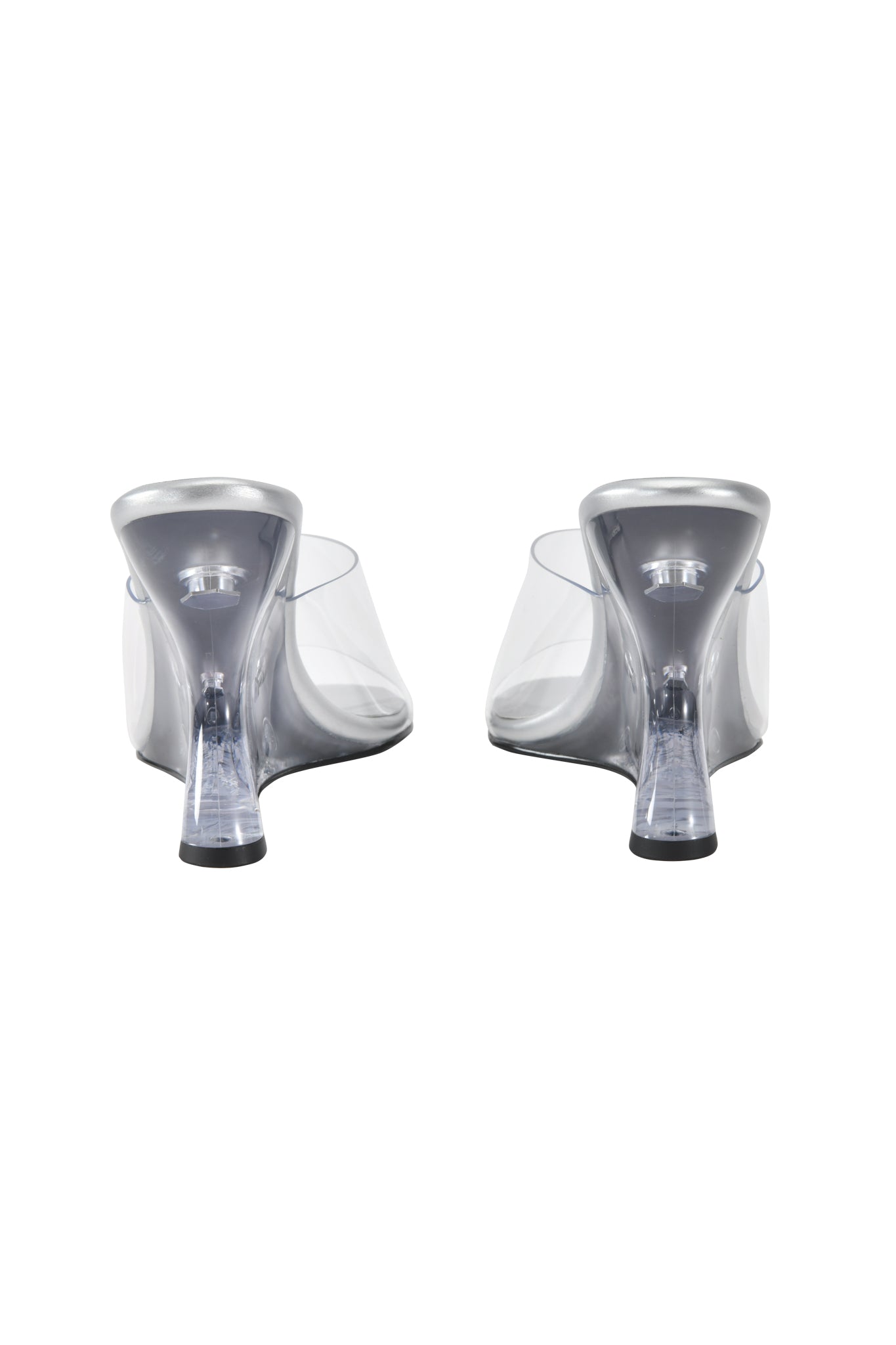 The I.AM.GIA RHEA CLEAR WEDGE HEEL - TRANSPARENT showcases clear vinyl straps, transparent wedge heels, and black soles in a striking sculpted design viewed from the back.