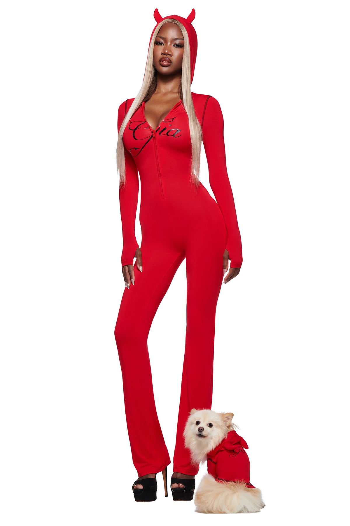 A woman stands confidently next to a small white dog in the T-REX BEST FRIEND BLARE HORN DOG HOODIE - RED by I.AM.GIA, both posing against a white background.