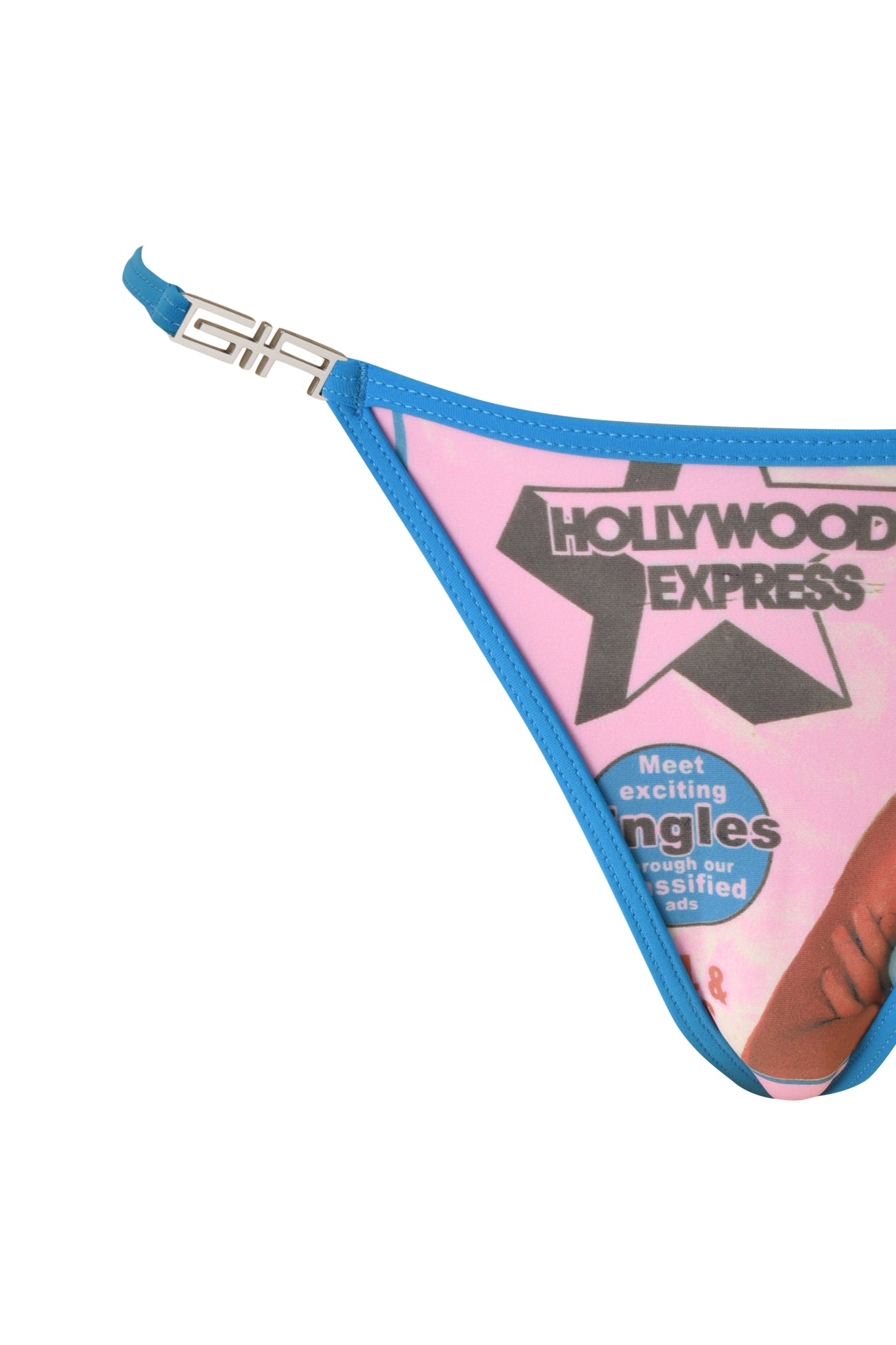 Close-up of a T-REX AVA BIKINI BOTTOM in pink by I.AM.GIA, featuring a partial magazine cover design with text that reads “Hollywood Express” and “Meet exciting singles,” plus a silver clasp on the strap.