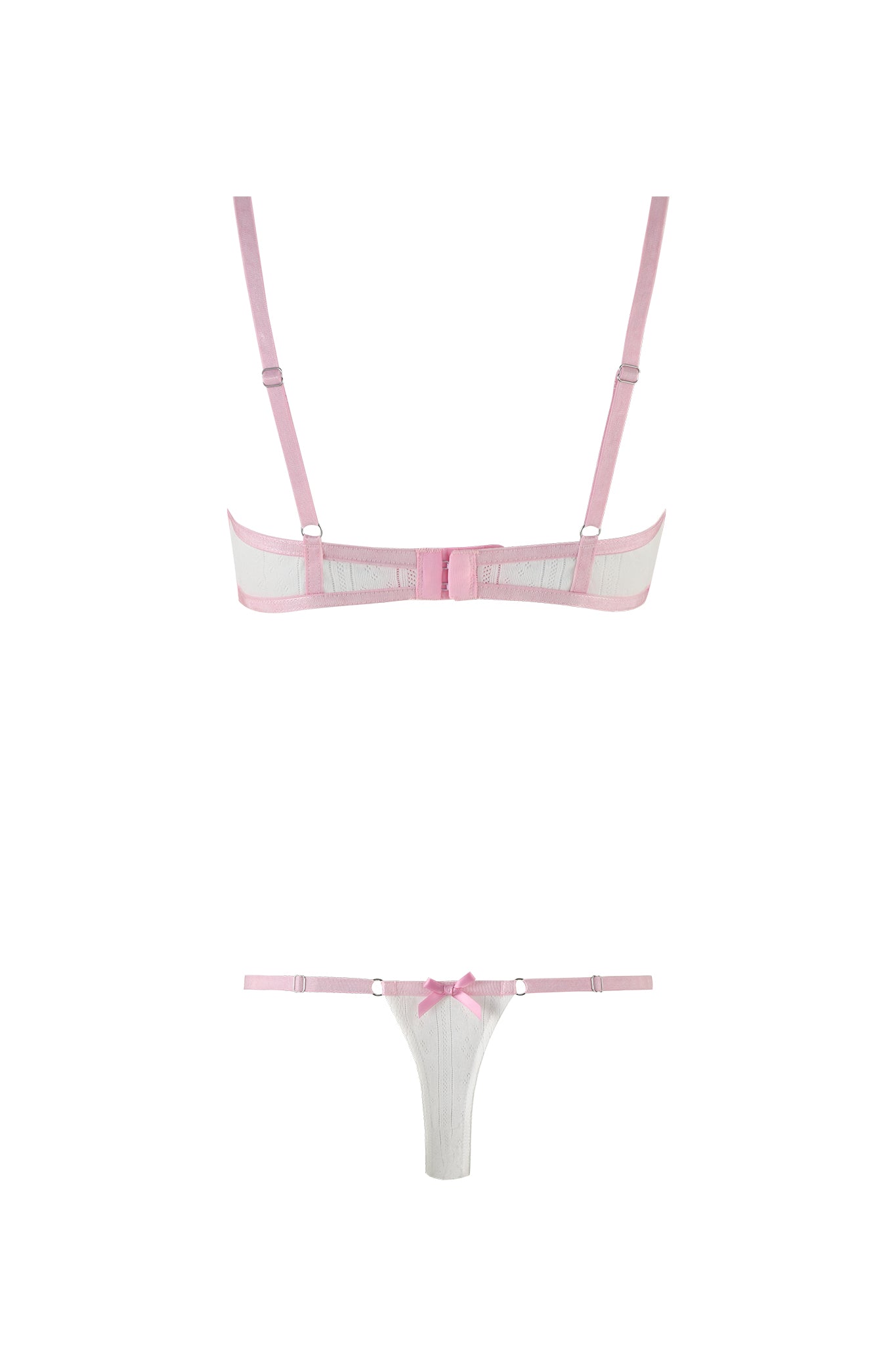 The SKYE SET - WHITE by I.AM.GIA features a pink and white pointelle design on a plain backdrop. This set includes a pink strappy bra with delicate lace trim, adjustable straps, and a hook-and-eye closure. It is paired with a matching thong adorned with a small bow on the waistband. Both pieces boast an elegant sheer mesh fabric.