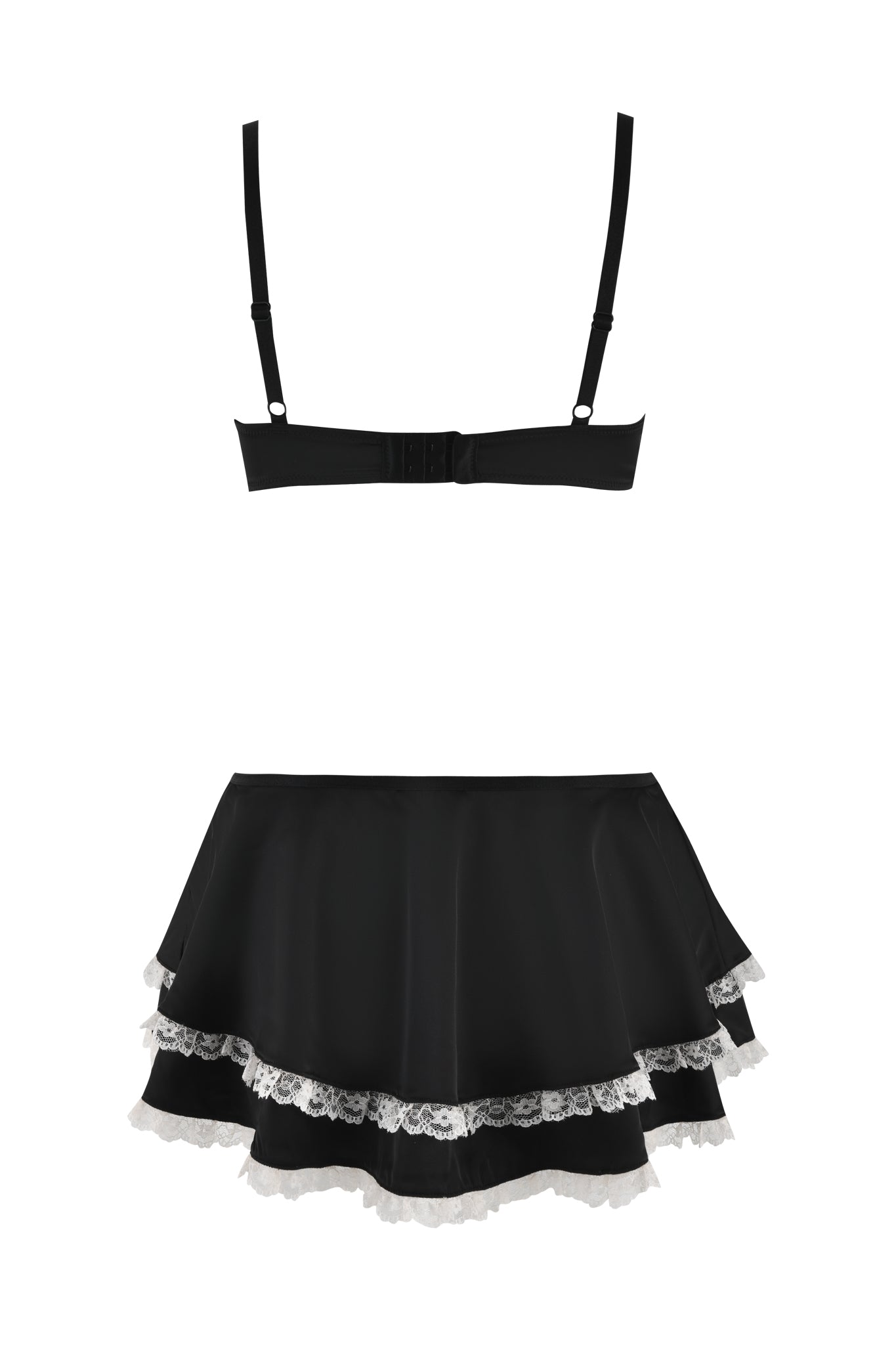 The Juliette Slip Dress in black by I.AM.GIA is a sophisticated lingerie set that includes a bra resembling a mini slip dress with adjustable straps and a hook-and-eye closure at the back. Complimenting this, the ensemble features a short skirt embellished with layers of white lace trim along the hem for an added delicate touch.