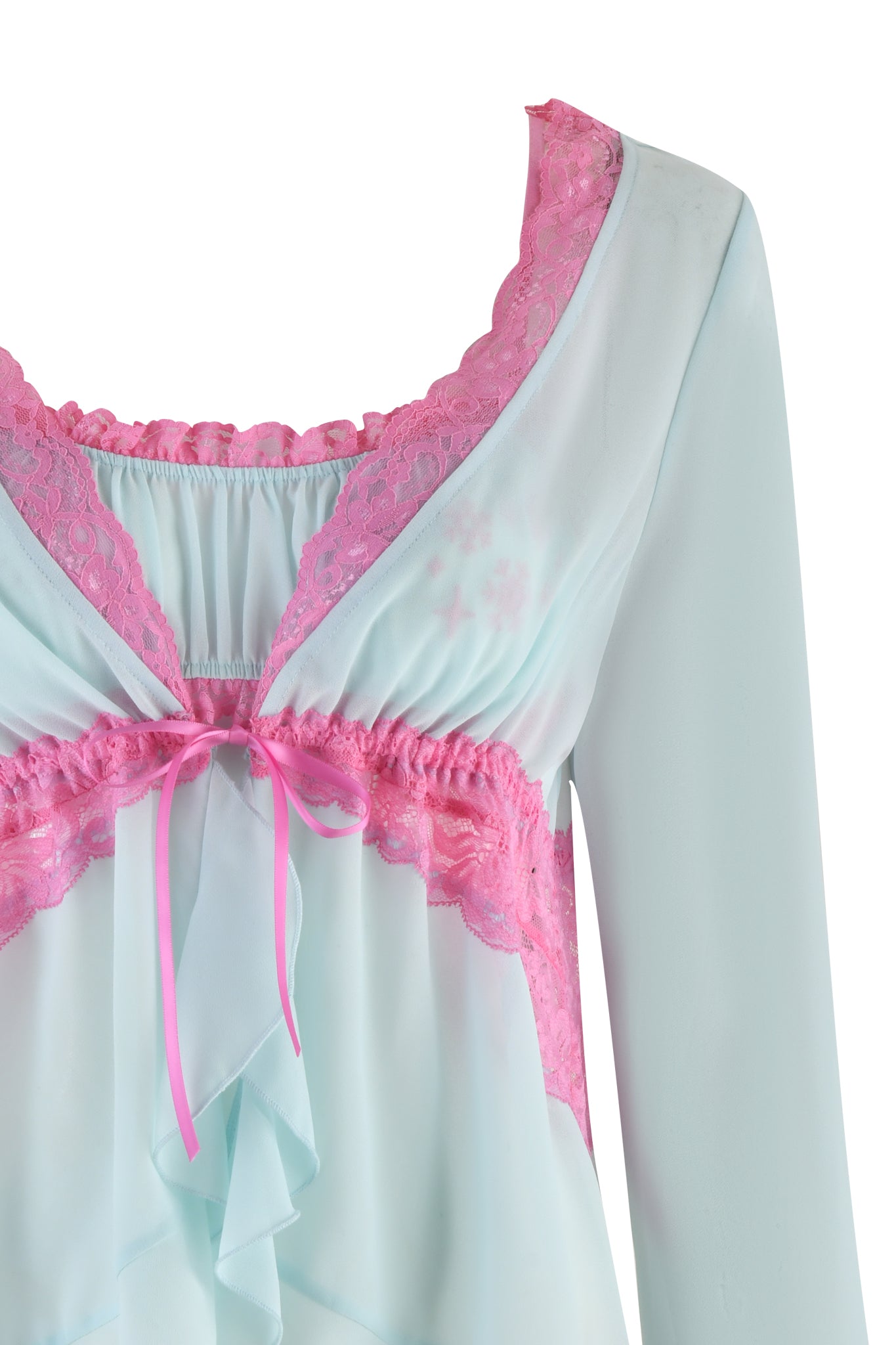 A light blue blouse with long sleeves, adorned with contrasting pink lace detailing around the neckline and a pink ribbon bow at the center, features a front ruffled design that complements the JUNIPER ROBE THREE-PIECE SET in mint green by I.AM.GIA.