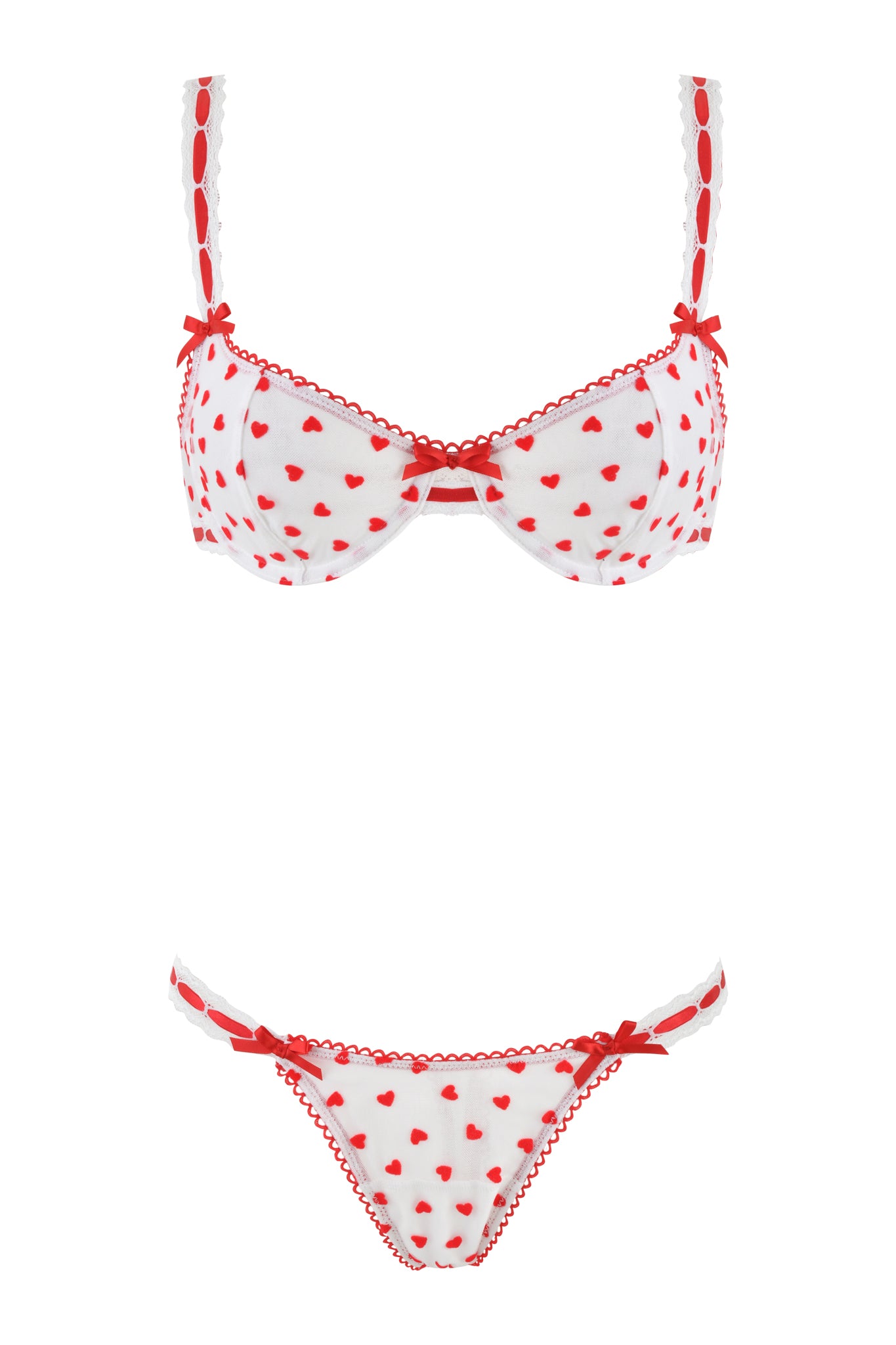 The ROMY 2 PIECE SET - WHITE: HEARTBEAT by I.AM.GIA evokes vintage charm with its white lingerie adorned in red heart patterns. The heart tulle bra has red ribbon details and adjustable straps, and the matching panties have similar touches. Both pieces are finished with a scalloped red trim.