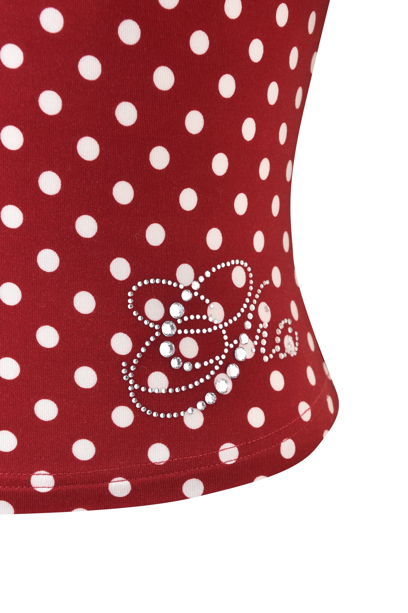 Close-up of the I.AM.GIA MELANIE CAMI - RED POLKA DOT, a bodycon cami top adorned with small rhinestones forming swirl and flower designs near the hem.