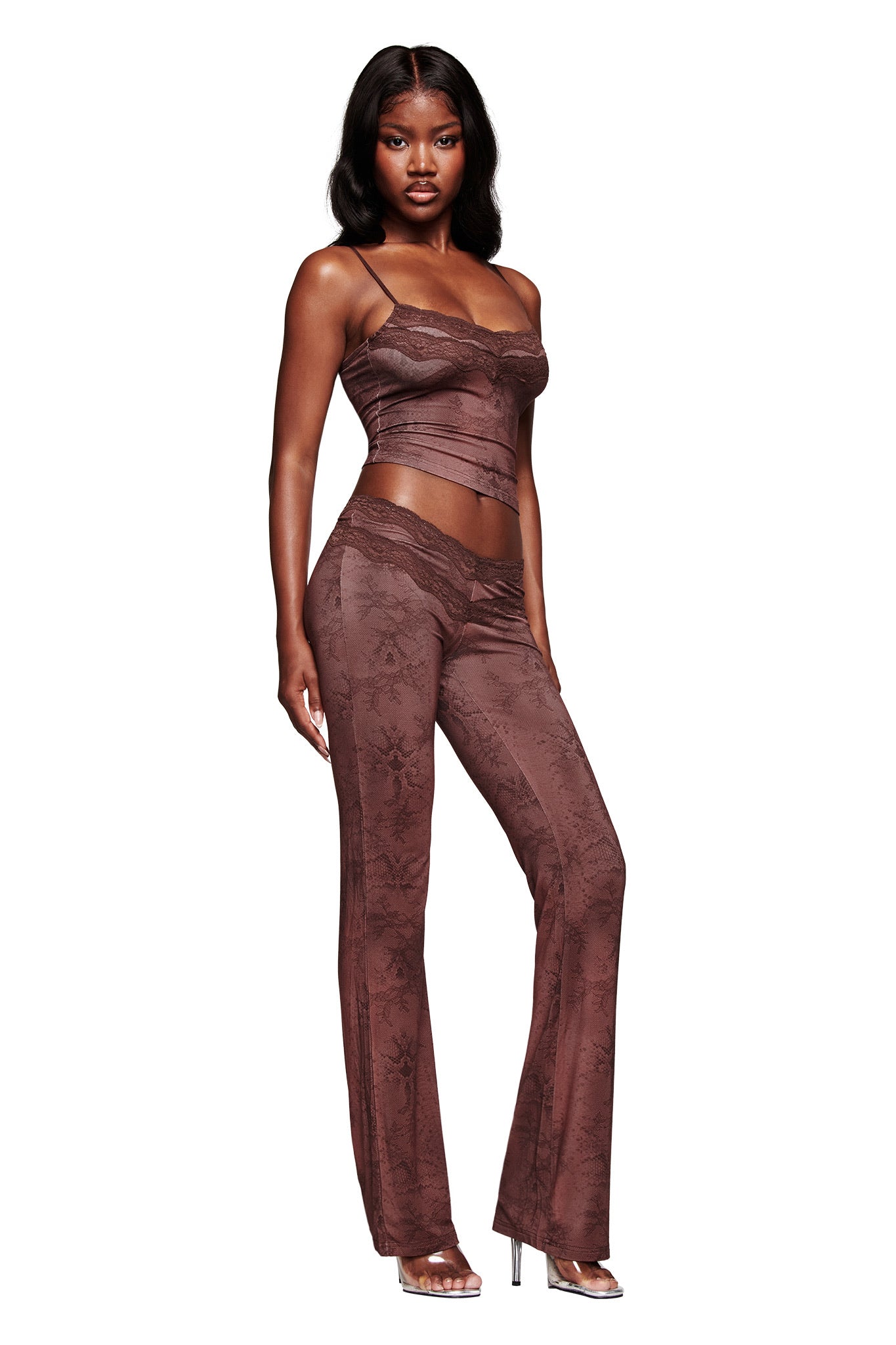 A woman models the I.AM.GIA BEAU TOP in brown with matching high-waisted lace-detailed pants and silver heels, posing against a white background.