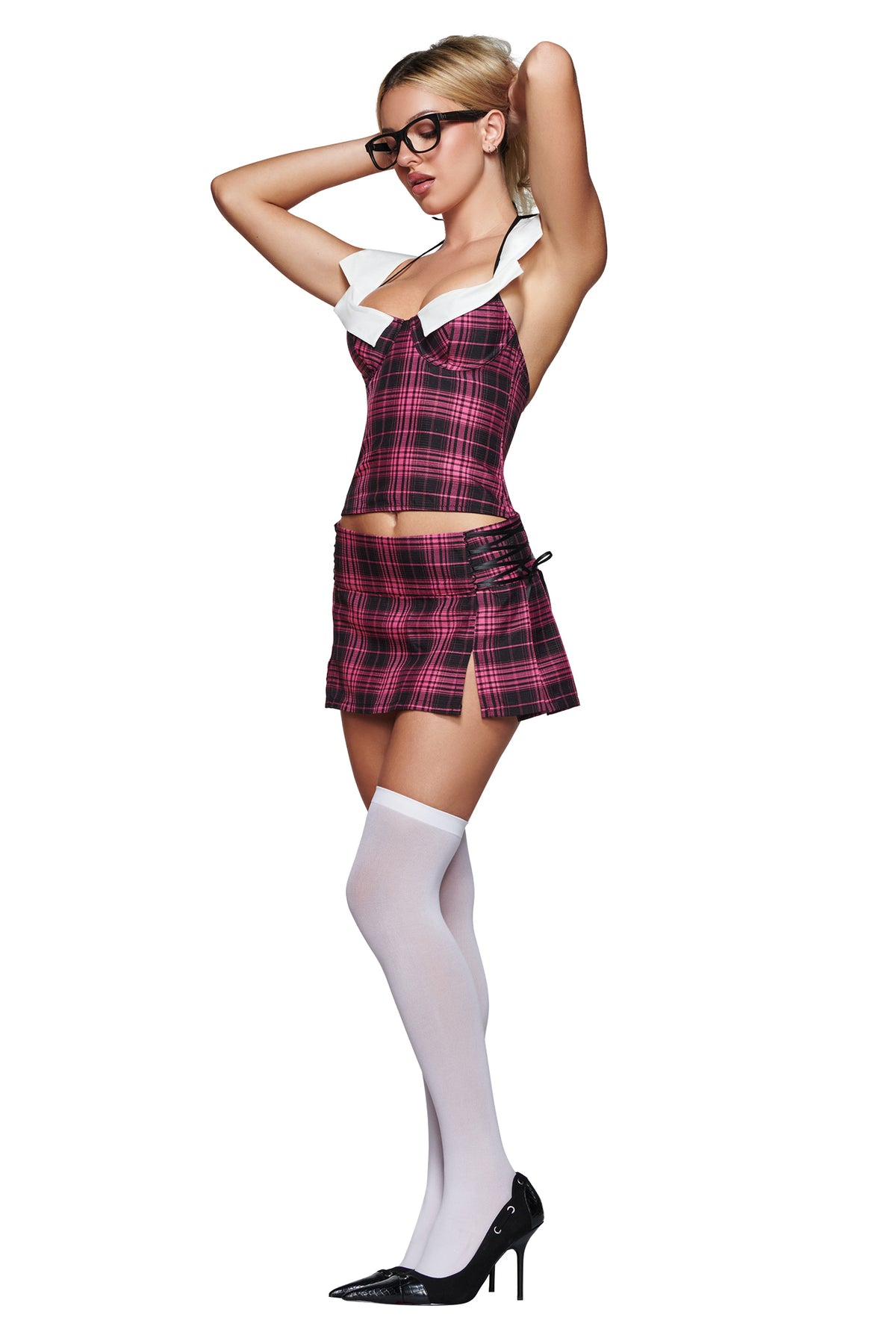 A woman poses against a white background, wearing the I.AM.GIA SOFI MINI SKIRT in pink plaid with a matching top, styled with white knee-high socks, black high heels, and glasses, her hands behind her head.