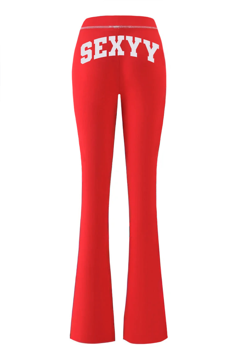 The I.AM.GIA X SEXYY RED BLARE TRACKPANT in bright red is shown from the back, with "SEXY" in bold white capital letters across the waistband.