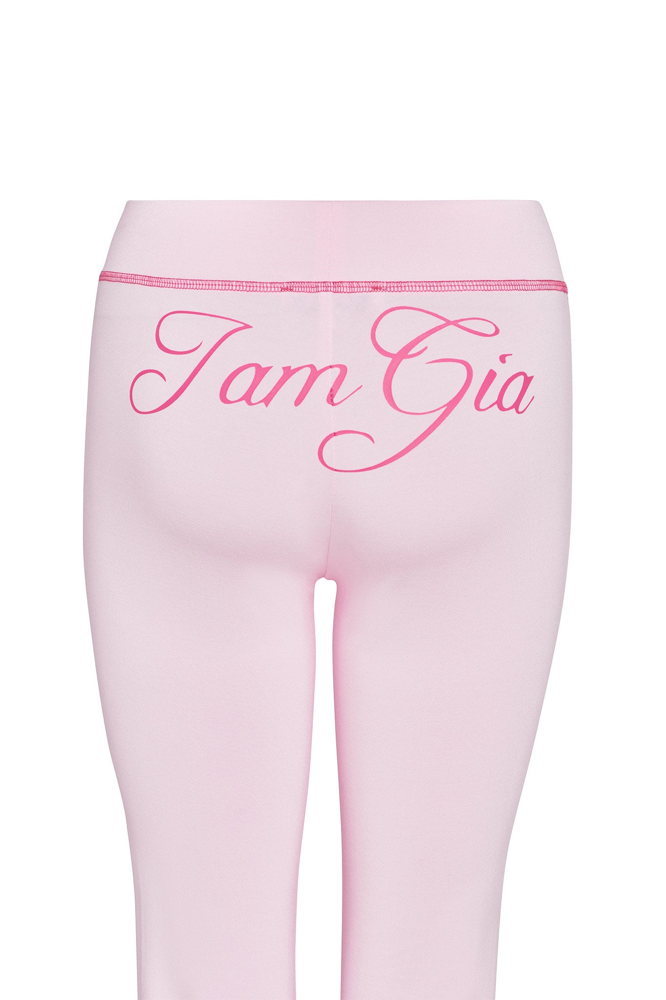 The image showcases the back view of a person wearing pastel pink Blare Trackpant from I.AM.GIA, with the brand's signature "I am Gia" elegantly scripted in a darker pink hue across the upper part. The form-fitting trackpants are smooth and made from stretchy bamboo fabric, ensuring both comfort and style.