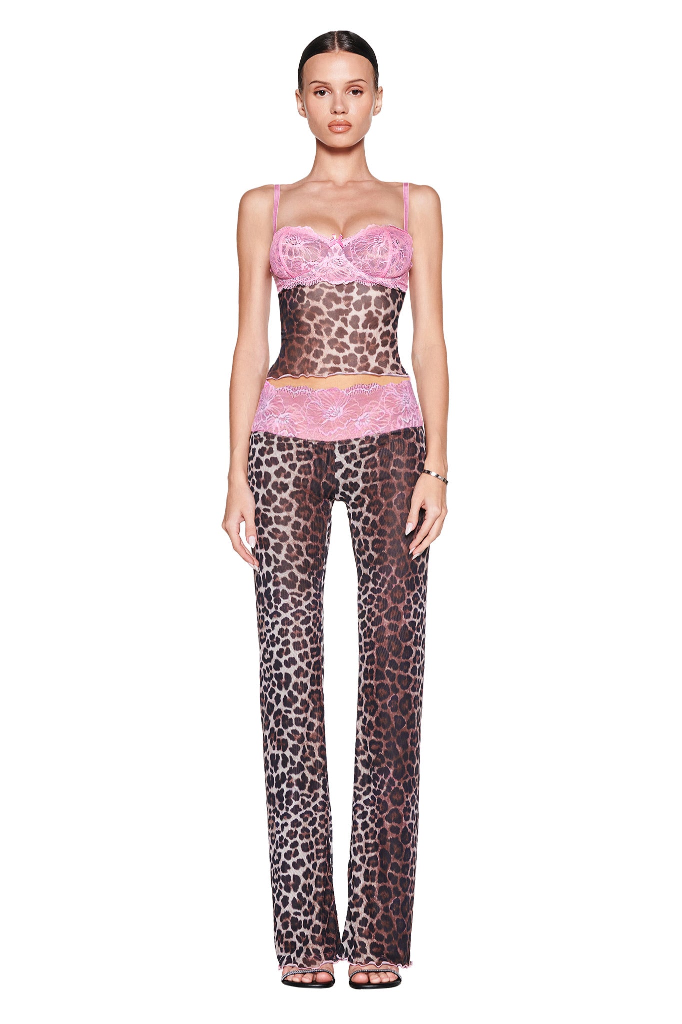 A woman faces forward against a plain white background, wearing the I.AM.GIA SILO PANT - CLASSIC LEOPARD low-rise sheer pant and matching top with pink lace accents.
