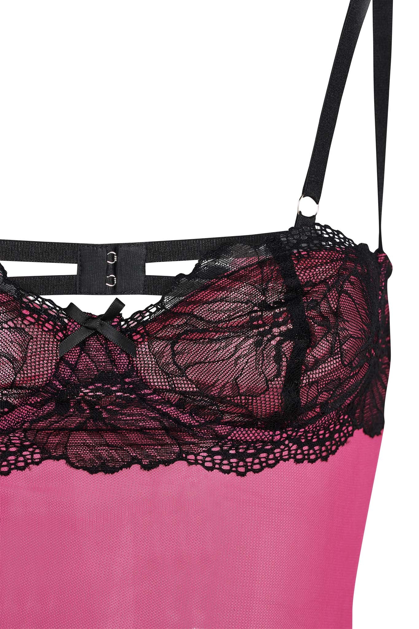Here is a detailed close-up of the I.AM.GIA SILO TOP in pink, showcasing intricate black lace detailing along the bust with black straps and a small black bow in the center. The floral patterned lace adds a delicate and elegant touch to the mesh fabrication of this garment.
