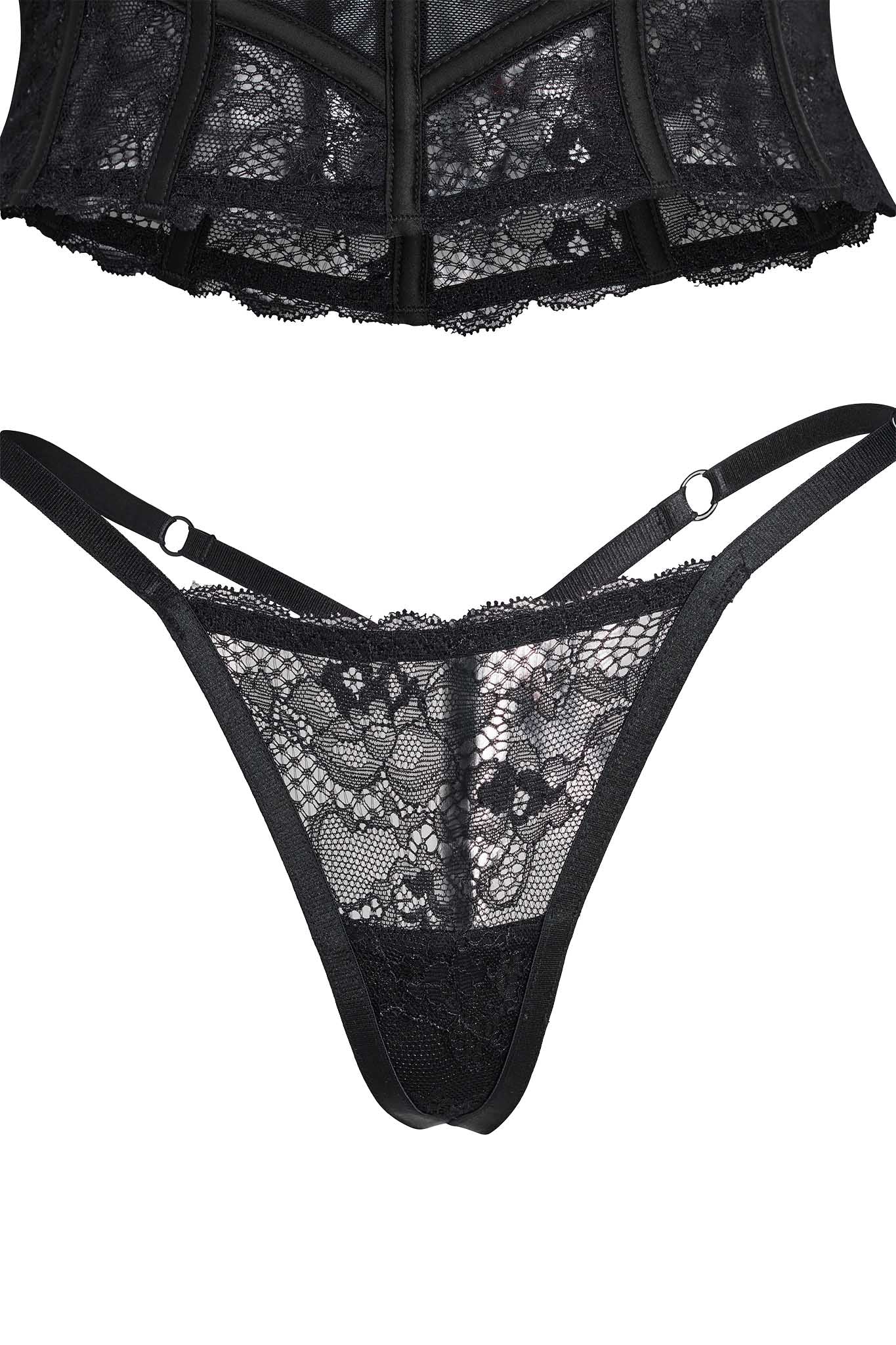 A close-up image showcases the VERUCA SET - BLACK from I.AM.GIA, featuring the lower part of a corset at the top of the frame and a matching pair of lace panties with thin side straps. The intricate lace pattern includes beautiful floral designs.