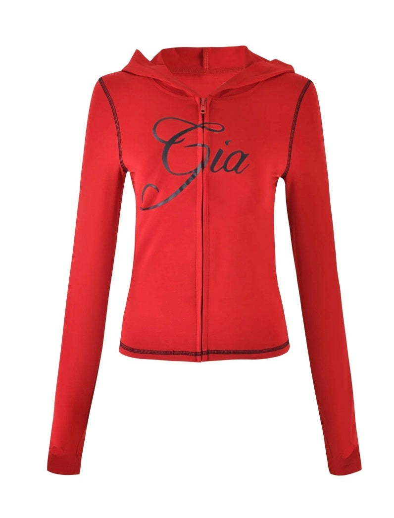 The BLARE HOODIE - RED by I.AM.GIA is a bright red bodycon hoodie with long sleeves, a zip-up front, black seam detailing, and “Gia” elegantly scripted in black across the chest, finished with a classic hood.