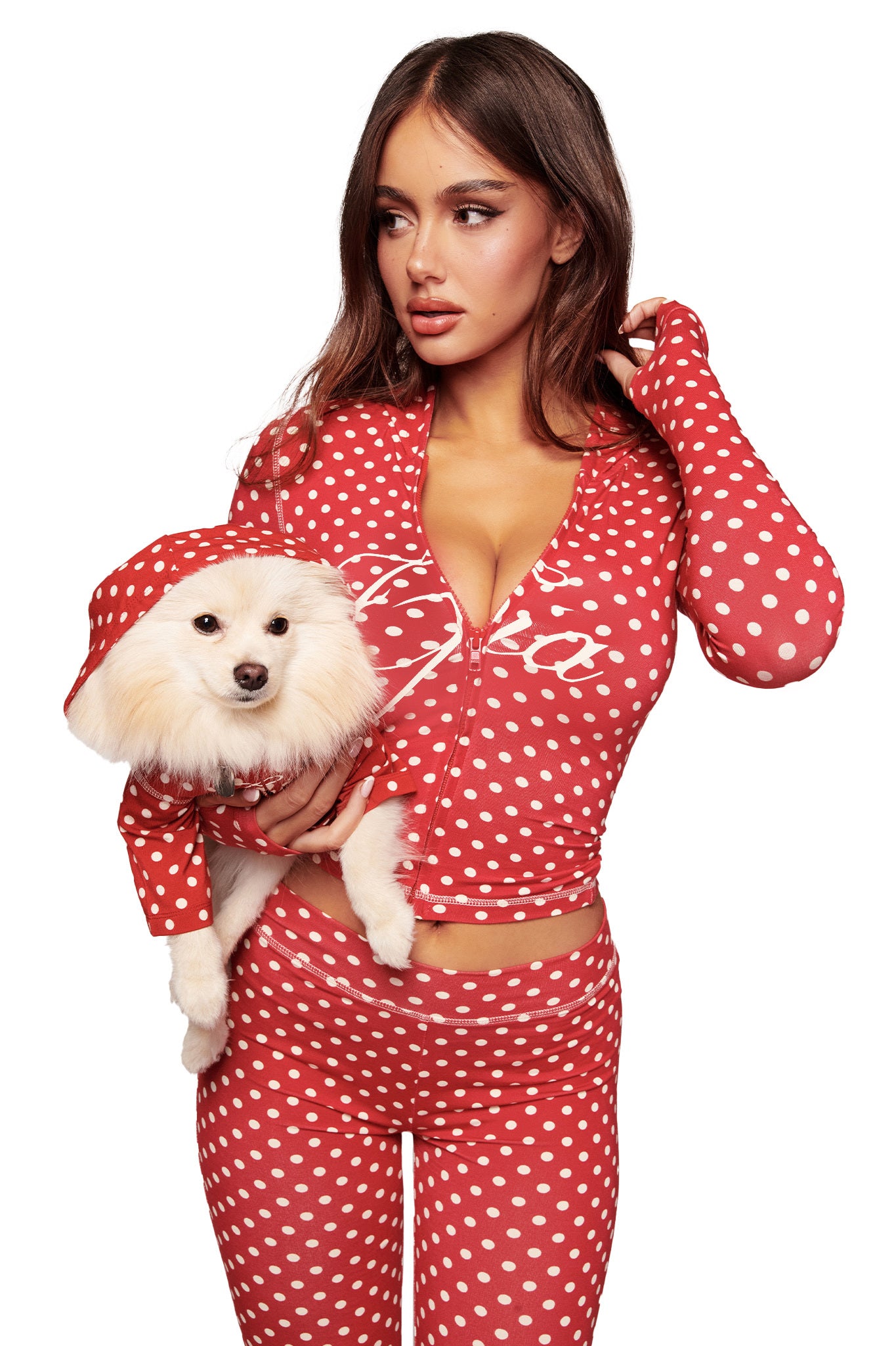 A woman and her small white dog wear matching I.AM.GIA BLARE BEST FRIEND DOG HOODIE - RED POLKA DOT sets, posing side by side against a white background.