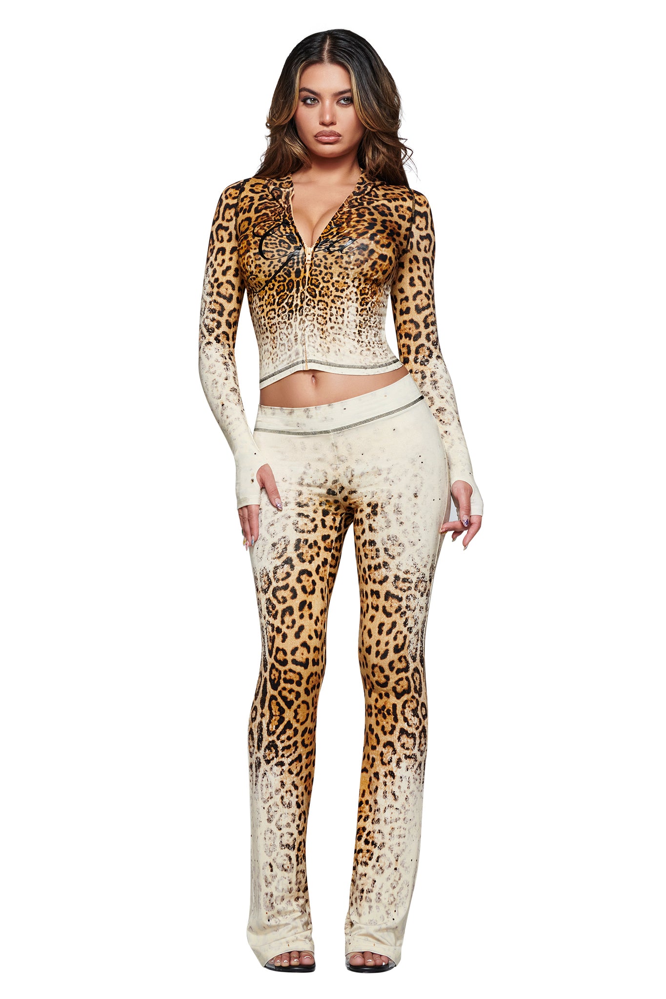 A woman standing and facing forward is wearing the I.AM.GIA BLARE HOODIE in Cream Faded Panthera, a matching long-sleeve leopard print hoodie and pants set with an ombre effect, crafted from soft bamboo fabrication, against a white background.