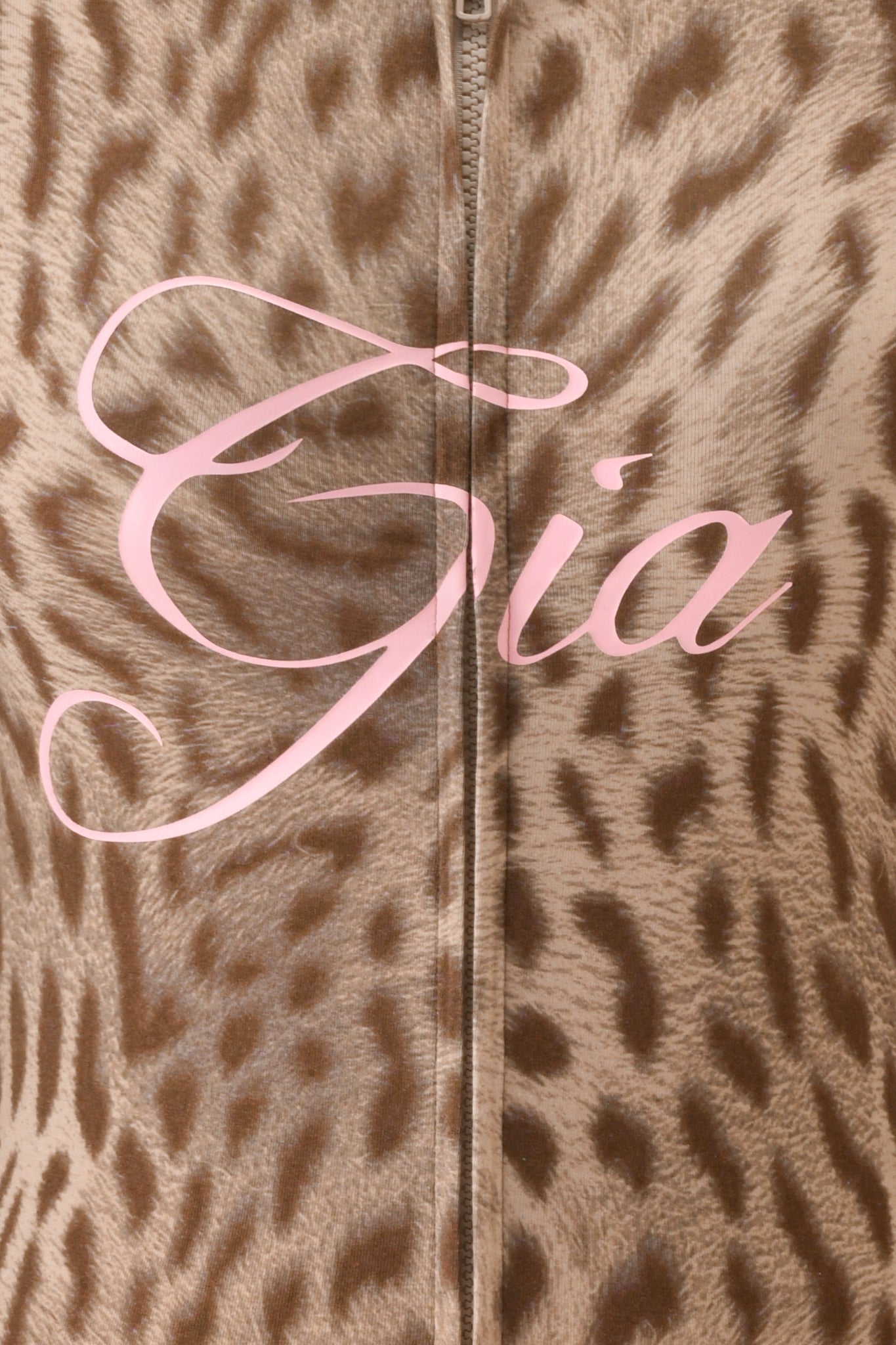 Close-up of the I.AM.GIA BLARE HOODIE - BLAZE CHEETAH, featuring brown and beige cheetah print fabric with a central zipper and "Gia" in large pink cursive across the middle.