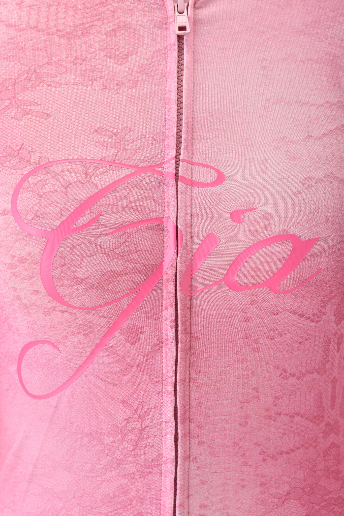 Close-up of the BLARE HOODIE - LIGHT PINK SERPENTINE by I.AM.GIA, featuring pink lace fabric, a center zipper, and "Gia" in elegant script. Inspired by the Pink Serpentine print for a sophisticated, modern style.