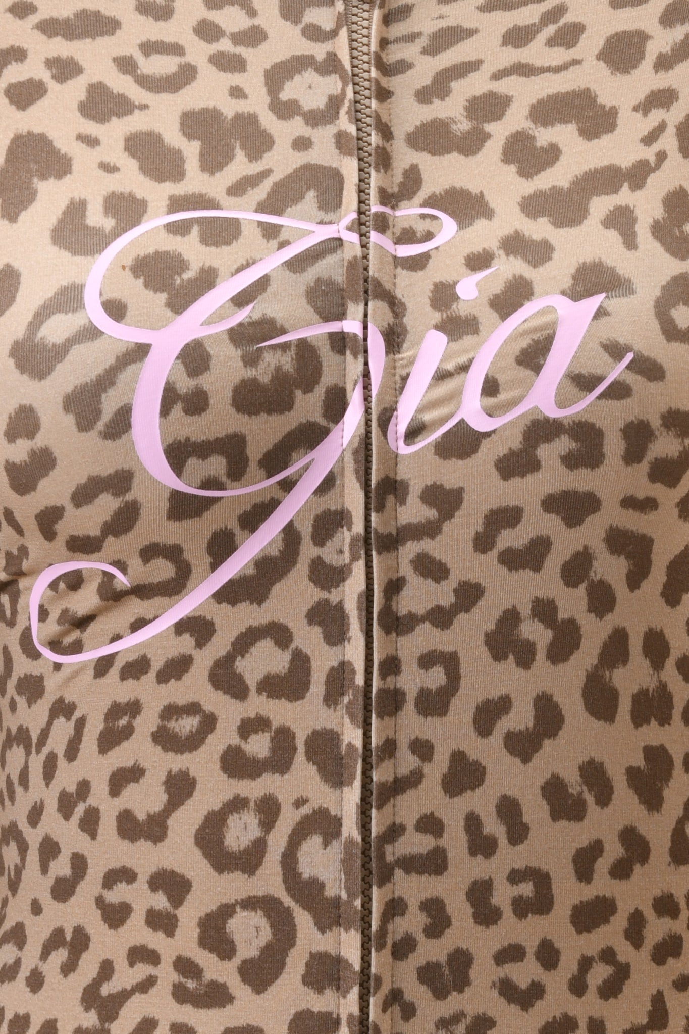 Close-up of the BLARE HOODIE - MOCHA LEOPARD by I.AM.GIA, featuring mocha leopard print fabric and “Gia” in large, light pink cursive across the chest, with a vertical center seam accentuating its stylish bamboo material.