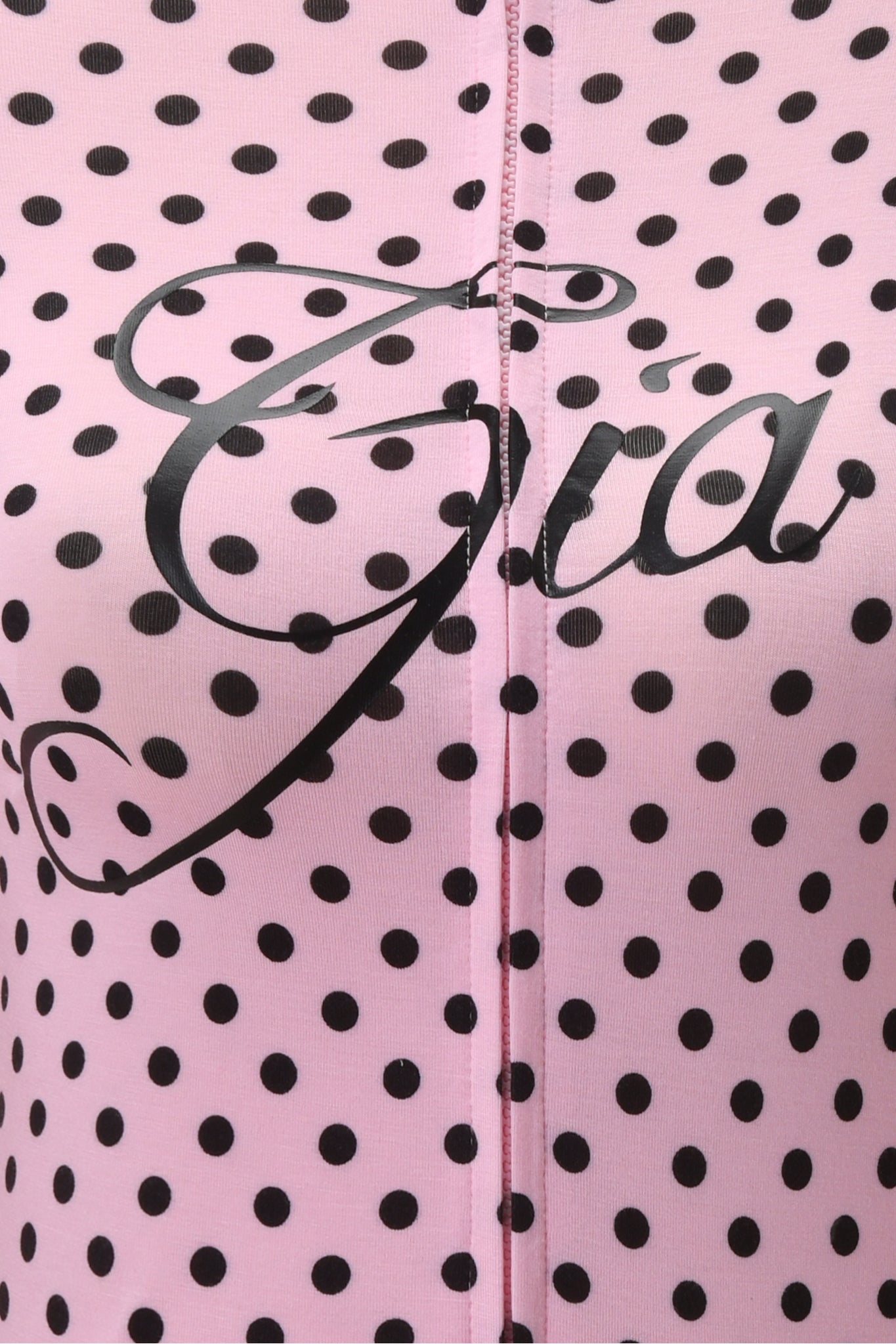 A close-up of the BLARE HOODIE - PINK POLKA DOT by I.AM.GIA shows pink polka dot fabric with "Gia" printed in bold black cursive and a center seam, highlighting its playful design.