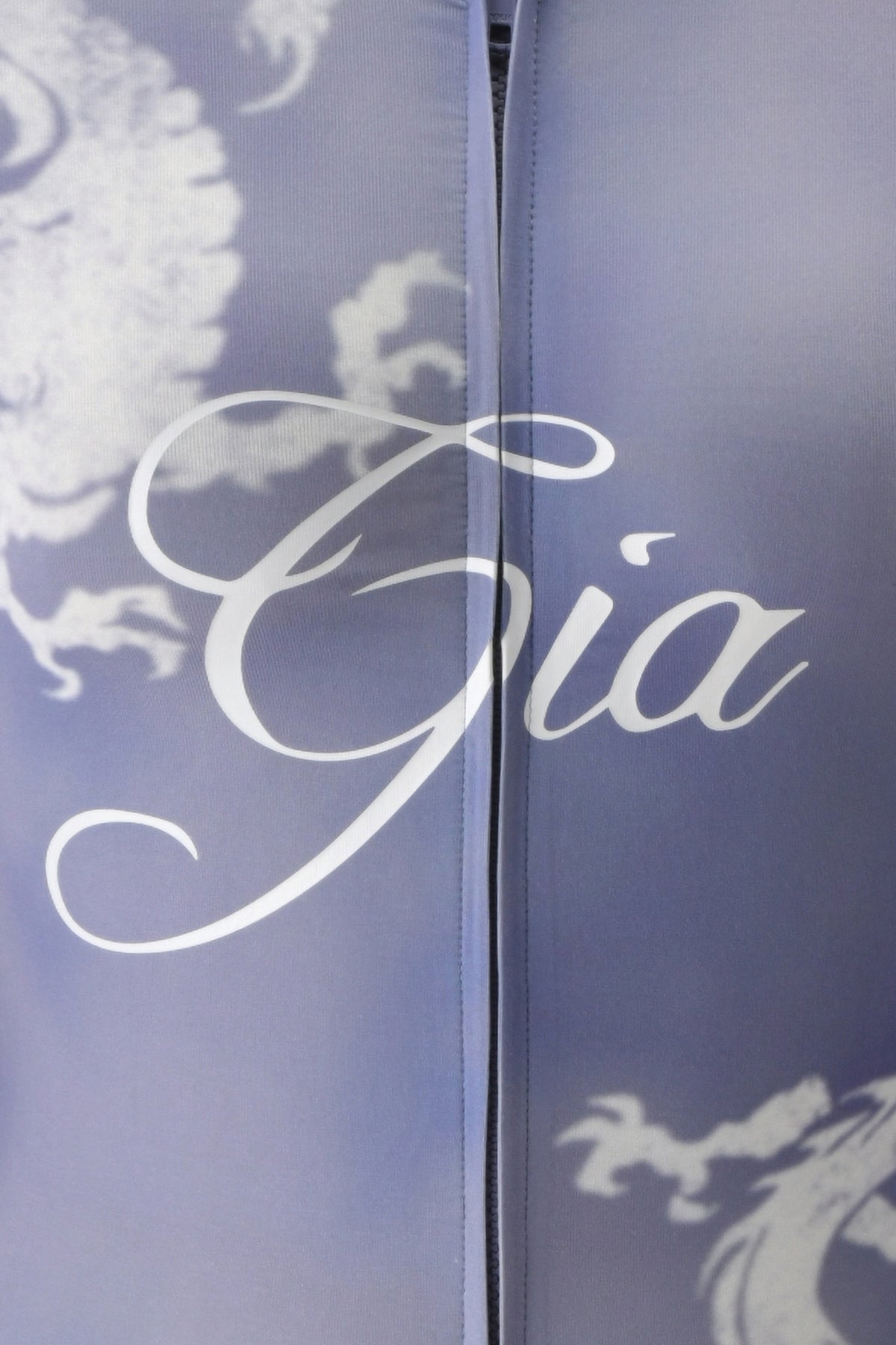Close-up of bamboo fabrication fabric featuring a lavender and white floral pattern, with the word “Gia” elegantly scripted in white across the center—echoing the refined details of the BLARE HOODIE - STEEL BLUE DRAGON by I.AM.GIA.