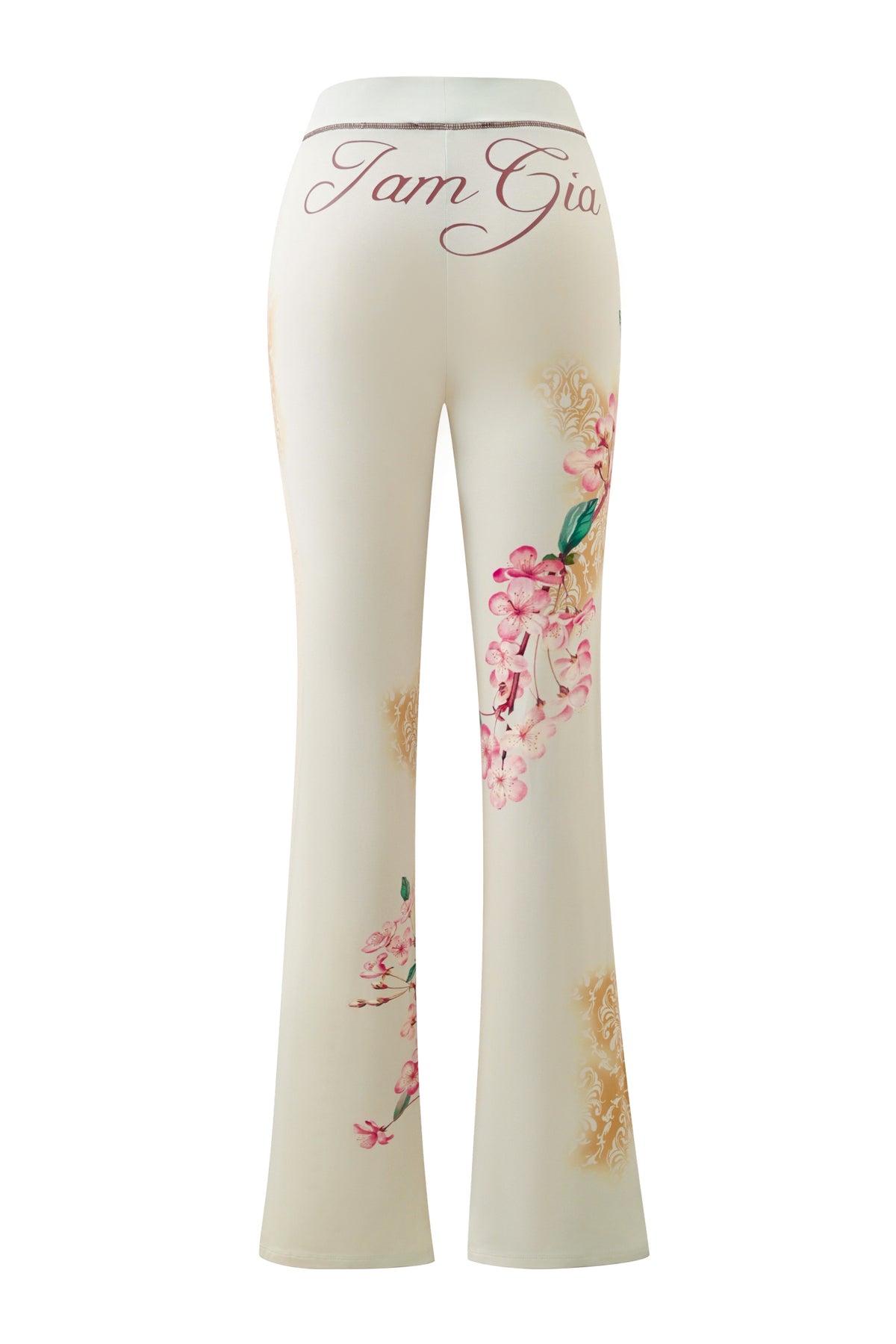 Introducing the I.AM.GIA BLARE TRACKPANT - BLOSSOM: high-waisted white trackpants adorned with pink floral prints and gold accents, featuring “Tam Gia” scripted across the back waistband. Reminiscent of classic I.AM.GIA style, these unique pants effortlessly combine bold design with comfort.
