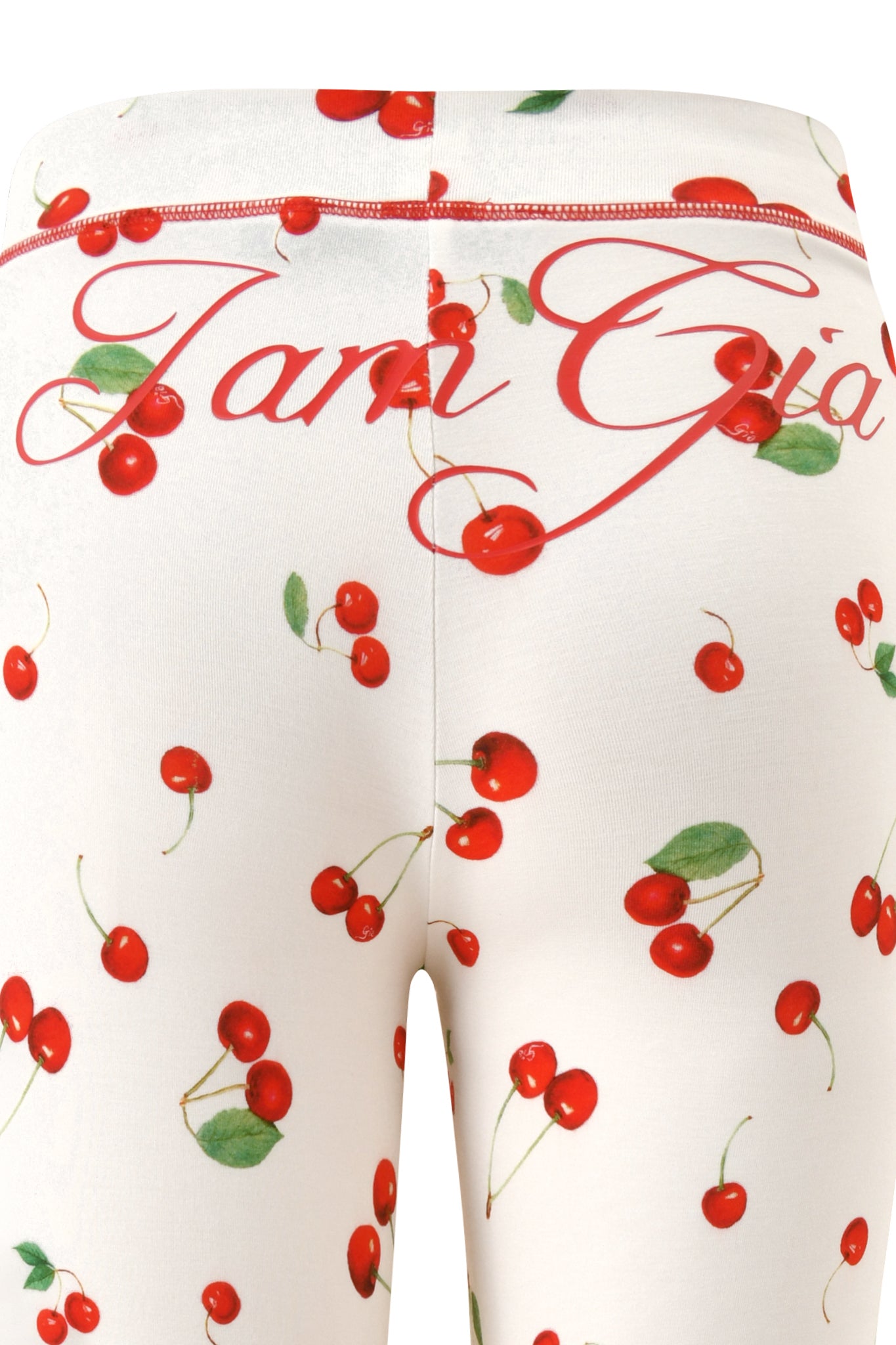 Close-up of I.AM.GIA's BLARE TRACKPANT - CHERRY ON TOP, showcasing white bamboo fabrication, a playful Cherry on Top print, and red cursive text across the waistband.