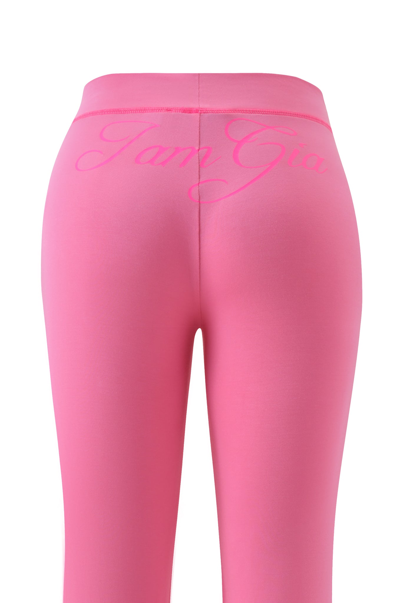 The BLARE TRACKPANT in neon pink by I.AM.GIA features flared legs and bold, matching pink I.AM.GIA branding in large cursive across the back waistband.
