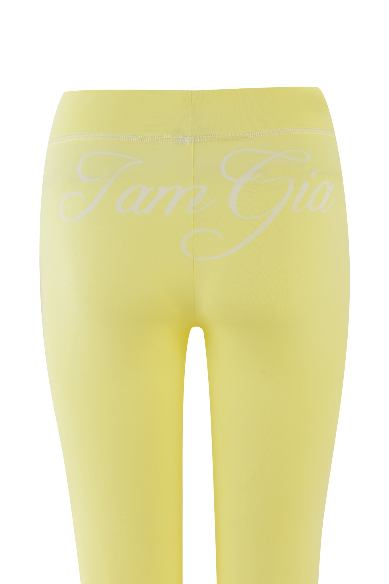 The BLARE TRACKPANT - YELLOW from I.AM.GIA features a pale yellow shade crafted from bamboo and jersey, with "Tame Gia" in white script on the back waistband, combining comfort and style against a plain white background.