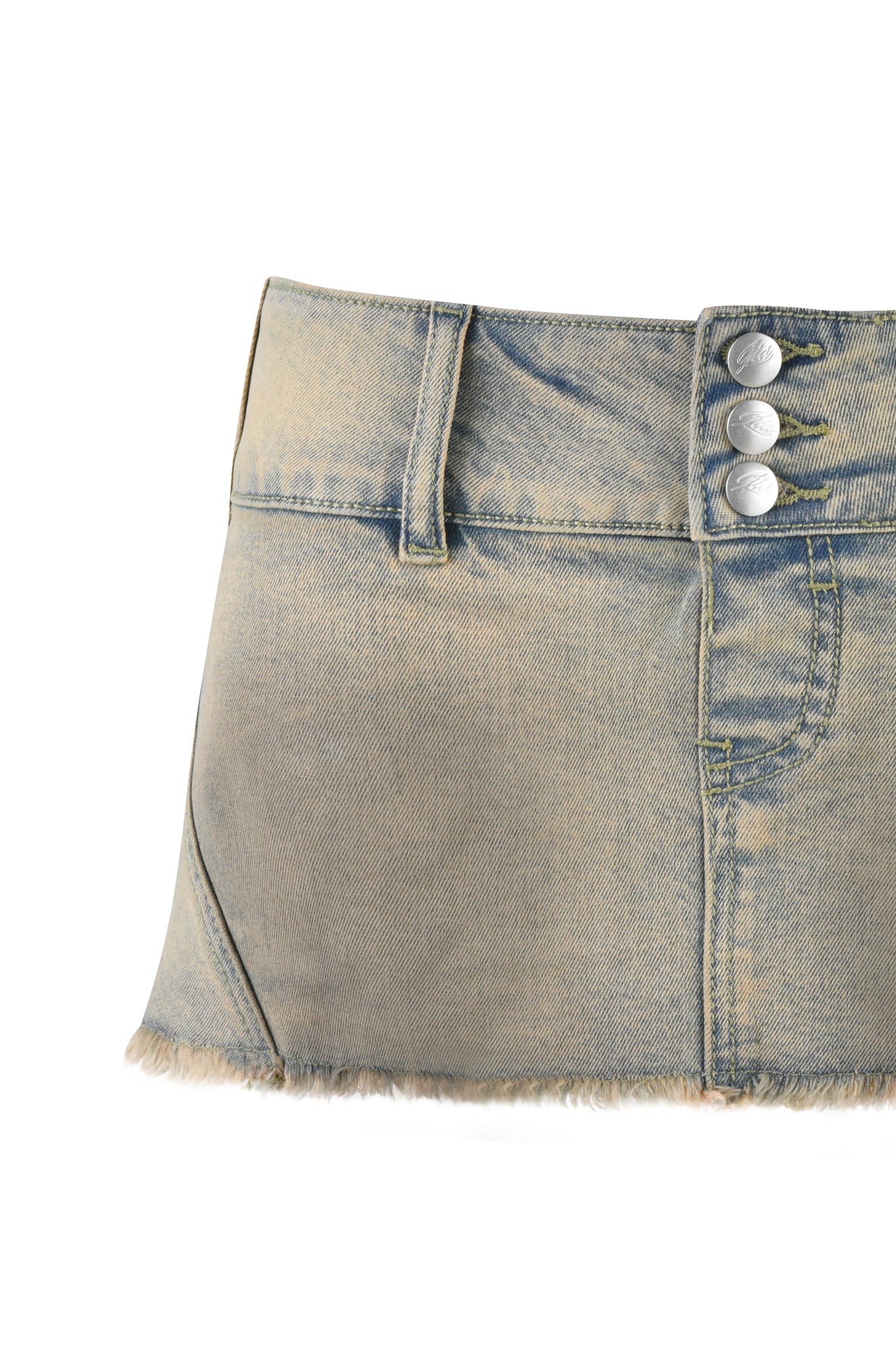 The NYKKO SKORT by I.AM.GIA in beige tan wash is a faded denim mini skirt with a frayed hem, low-rise waistline, three metallic buttons on the waistband, and two front pockets, set against a white background.