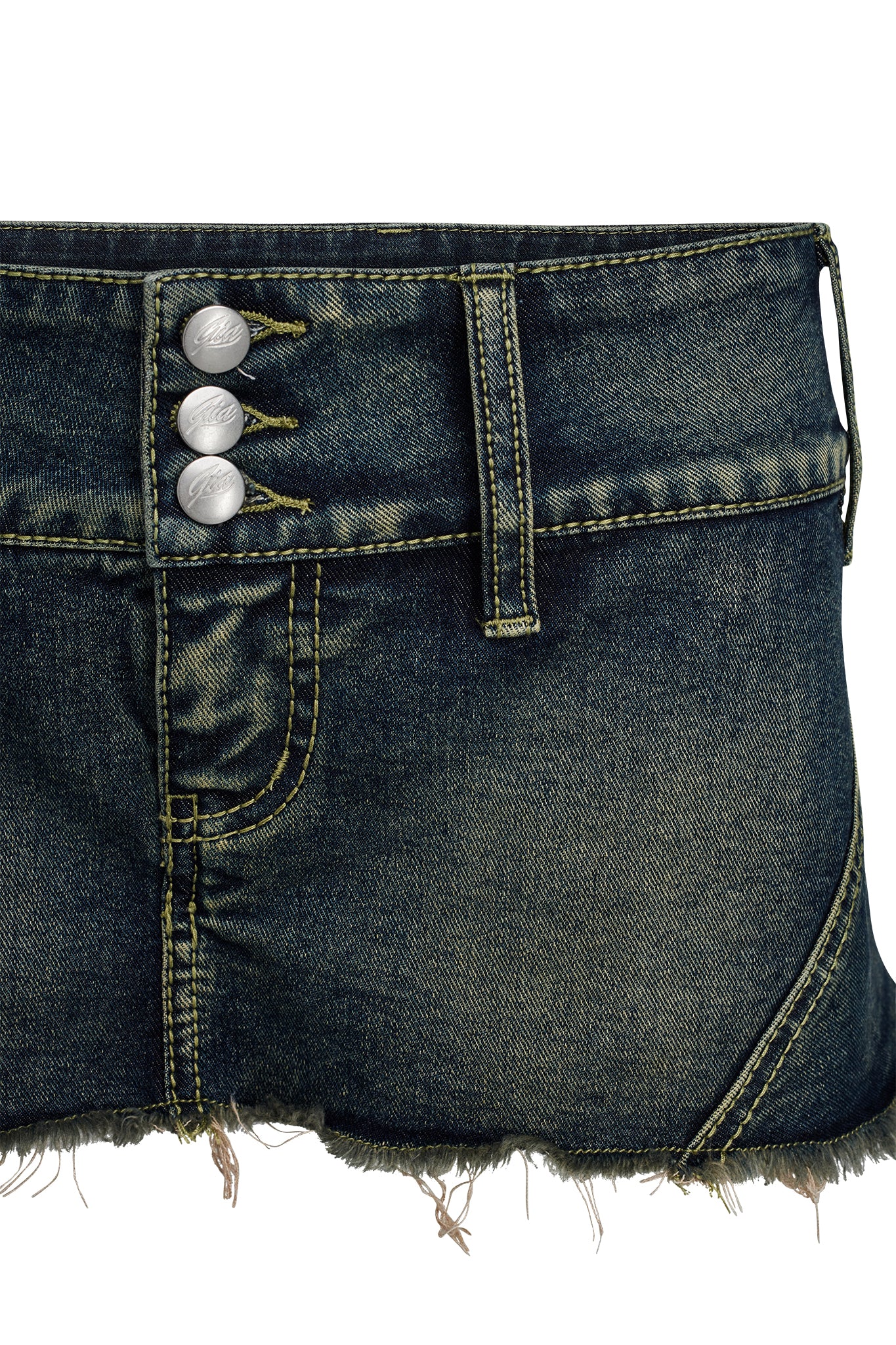 Close-up of the NYKKO SKORT in Denim Blue by I.AM.GIA. This dark denim skort features three silver buttons, prominent stitching, and belt loops. The fabric displays a slightly worn texture and color variations, contributing to its vintage aesthetic.