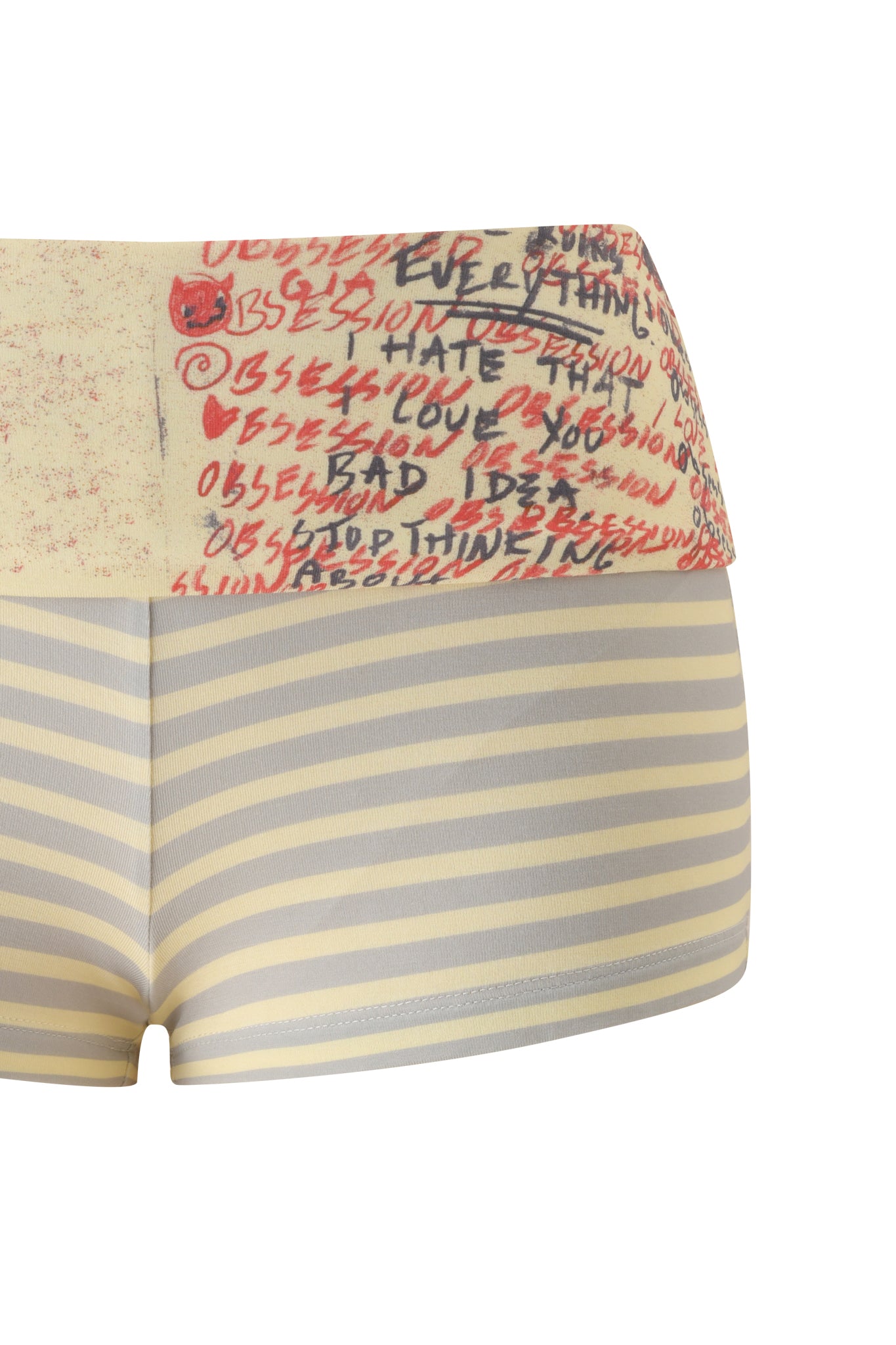 The I.AM.GIA T-REX BLARE 2.0 SHORT - YELLOW features a high-waisted, bodycon fit with horizontal beige and gray stripes. The foldover waistband is decorated with red and black handwritten text and doodles, including the word "OBSESSION" and a small red devil face.