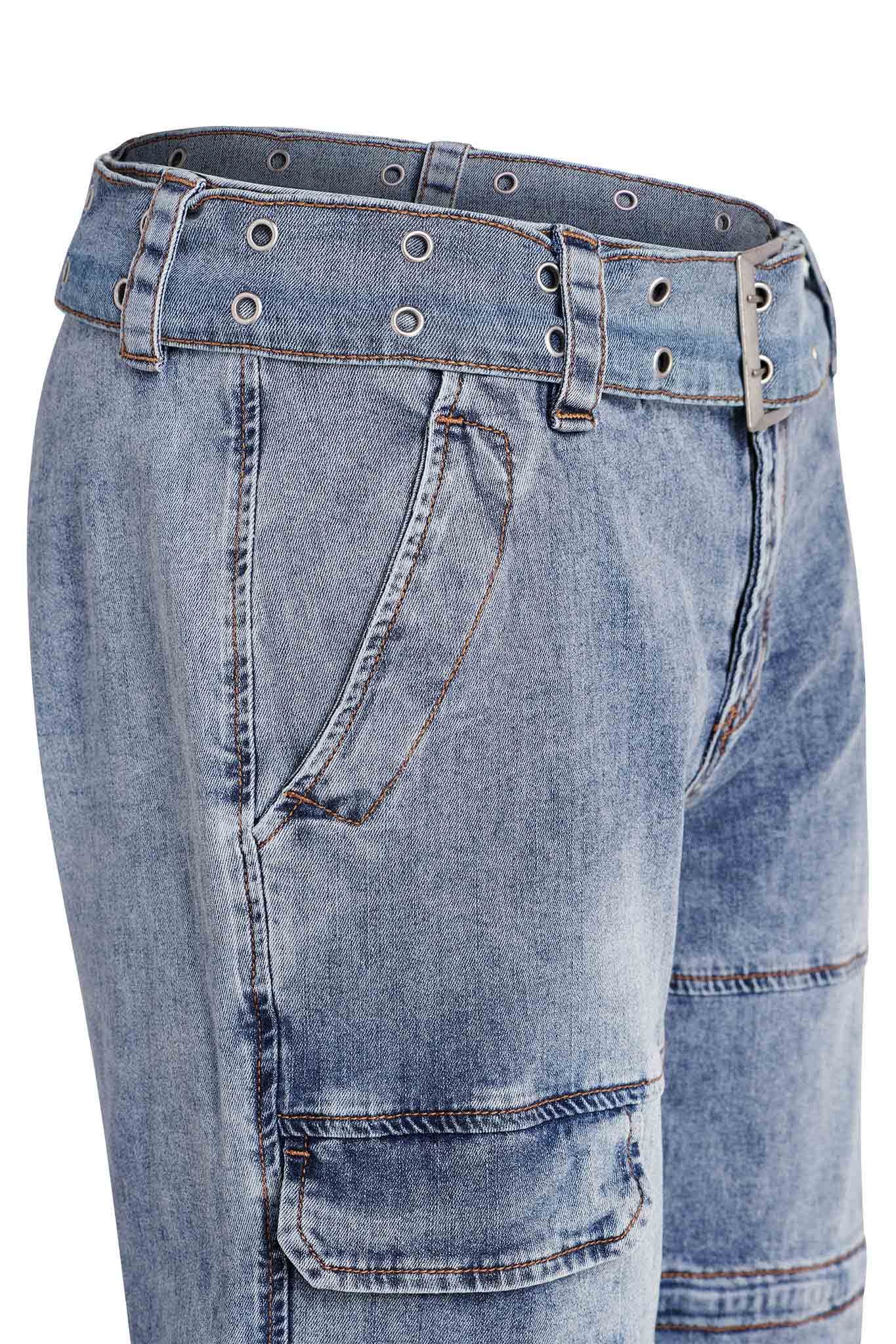 Close-up of the NAIMA CARGO PANT - DENIM by I.AM.GIA, showcasing a pair of blue denim jeans with a matching denim belt featuring multiple metal eyelets. The jeans offer detailed stitching and visible side pockets, presenting a slightly worn vintage look with patchwork-style seam detailing.