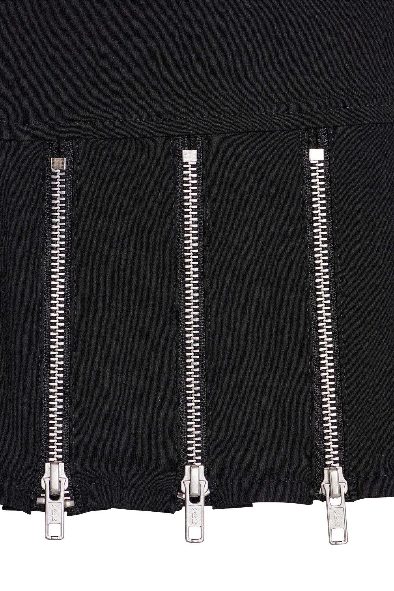 Close-up of the Claudia Skirt in black by I.AM.GIA, featuring four vertically aligned metallic zippers. The zippers are evenly spaced with silver-toned teeth and sliders, and the pull tabs hanging down.