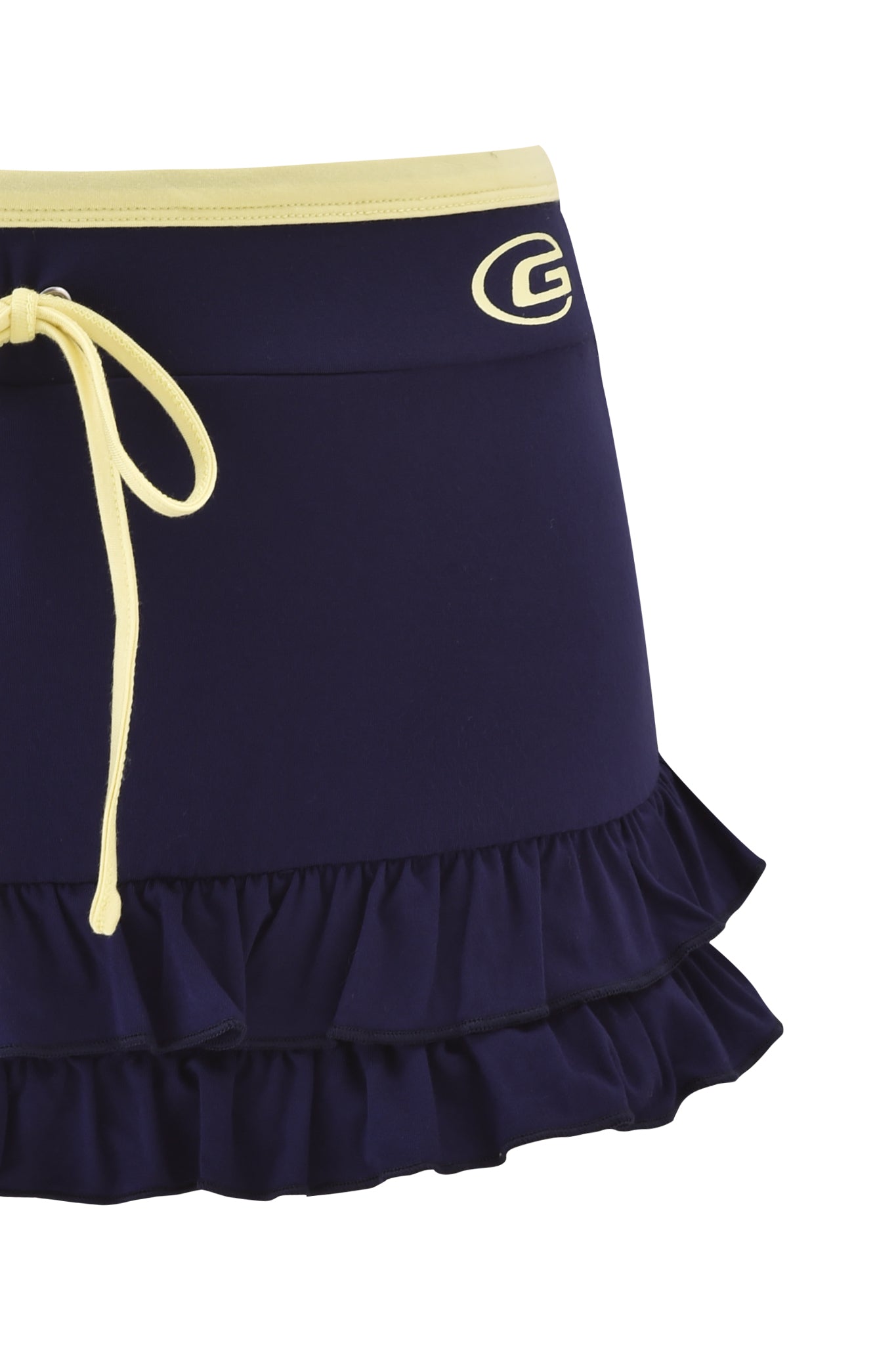 The MICHELLE SKORT - NAVY by I.AM.GIA is a navy low-rise mini skort with a yellow waistband and tie, white "G" logo at the waist, and layered ruffle hem for standout style.