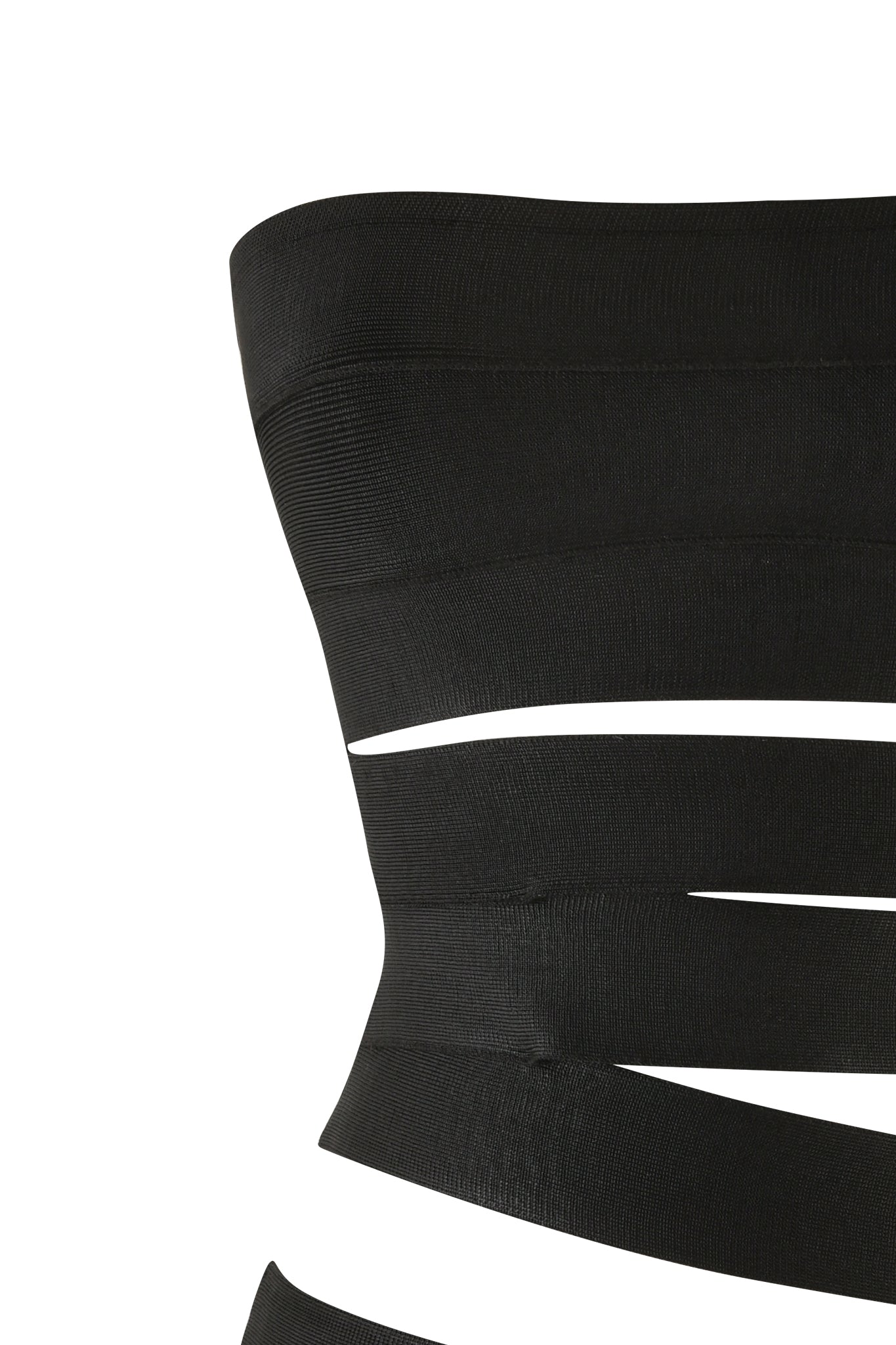 Close-up of the FLAVIA MINI DRESS - BLACK by I.AM.GIA, featuring a strapless neckline and multiple horizontal cutouts. The body-hugging design creates a pattern of narrow strips, revealing the white background behind them, making this mini-length bodycon dress both striking and chic.