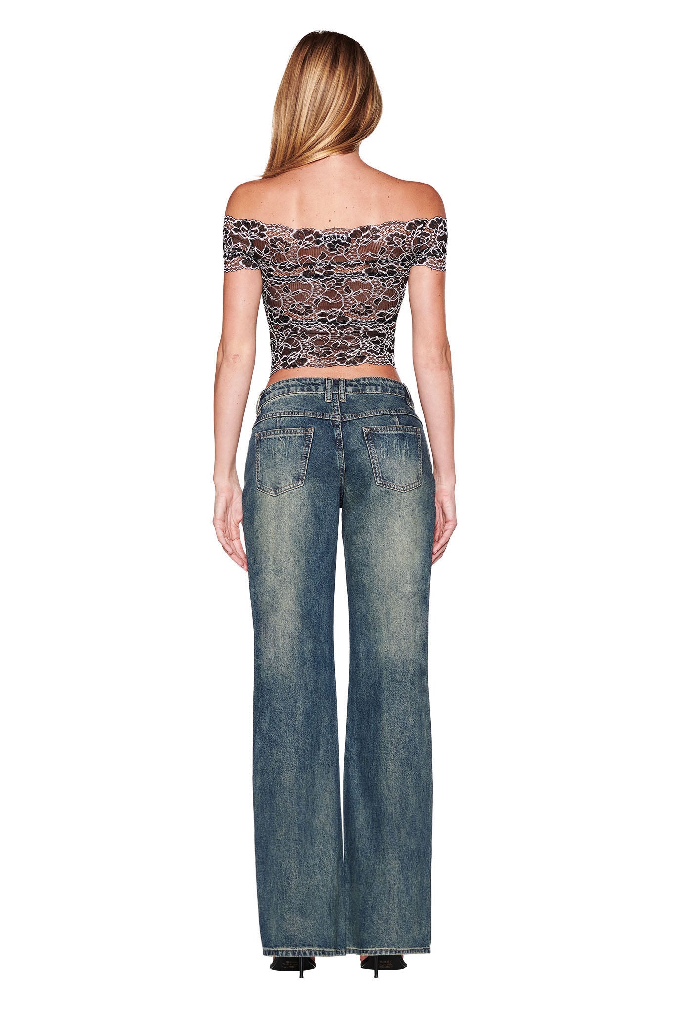 A person with long hair is wearing a black lace off-shoulder top and wide-leg DYLAN JEAN - BLUE DENIM from I.AM.GIA, viewed from the back. The high-waisted jeans have a faded, vintage look.