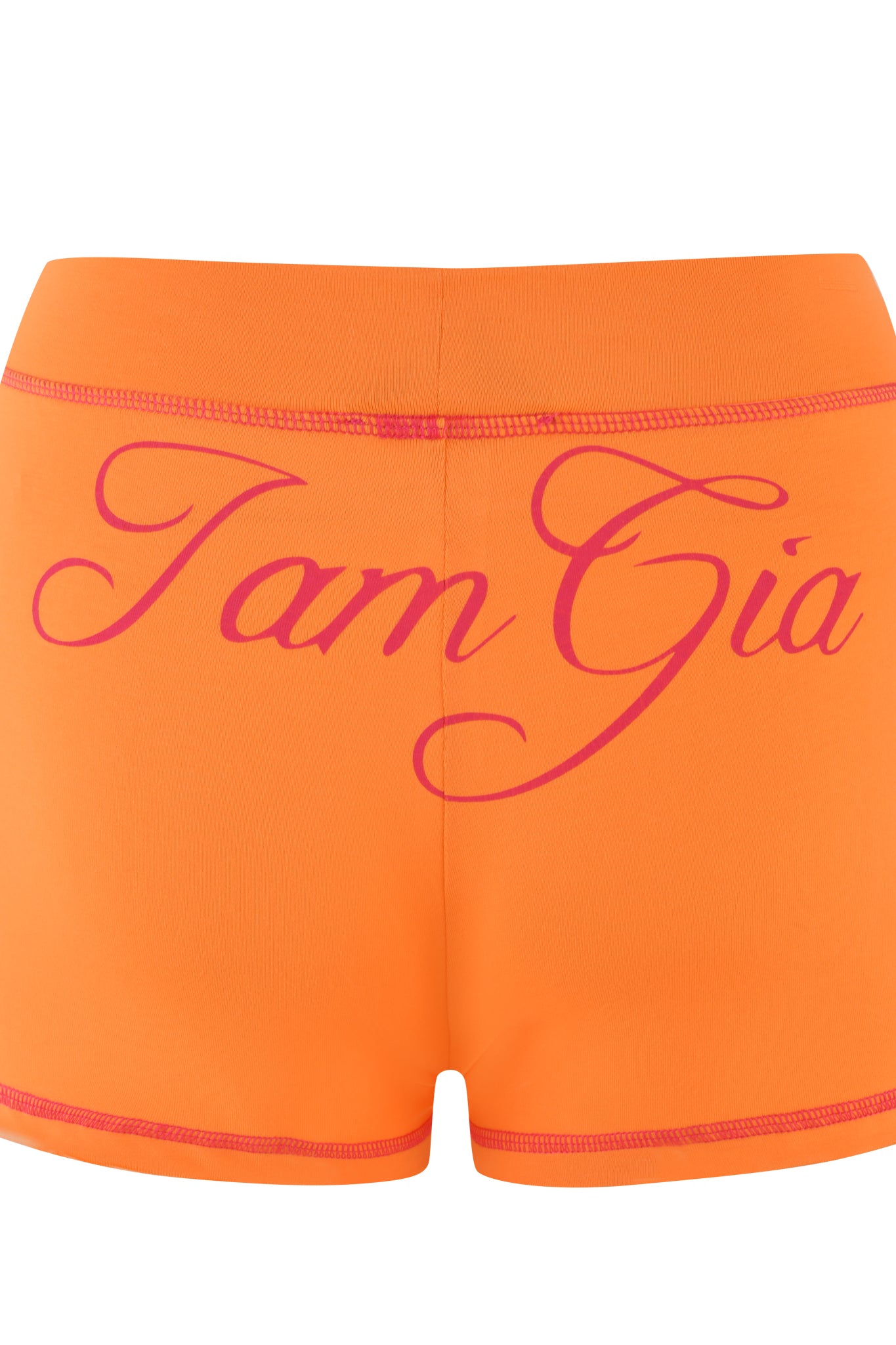 The BLARE SHORT - ORANGE by I.AM.GIA features pink stitching and large cursive text "I am Gia" on the back, offering a flattering bodycon fit. Made from eco-friendly bamboo, they provide comfort and sustainability.