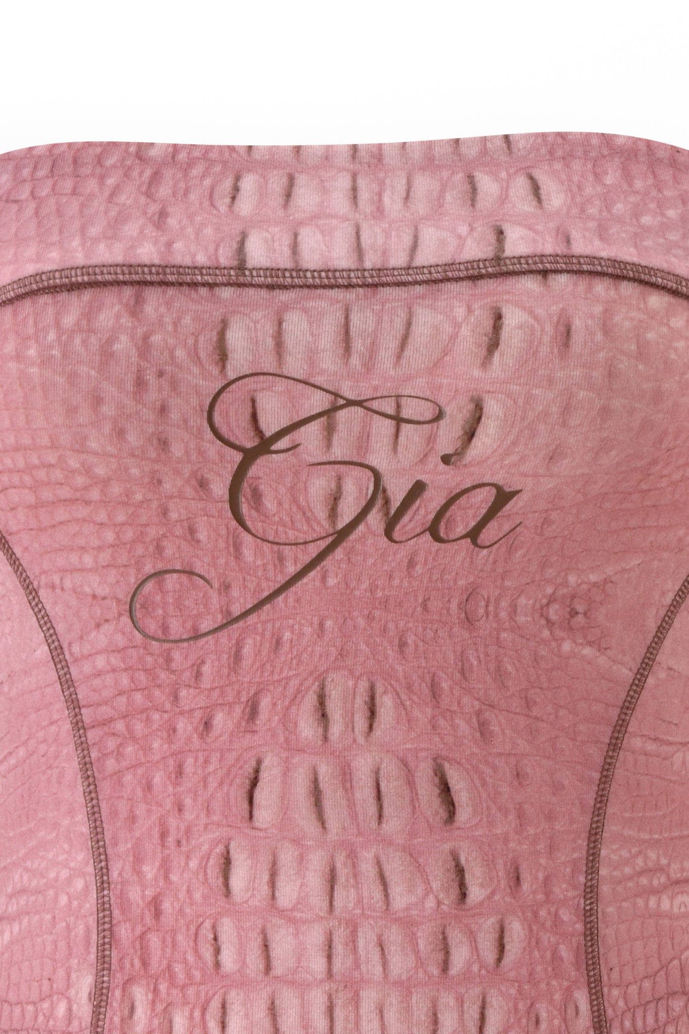 A close-up of the BLARE TUBE MINI DRESS - HOT CROC PINK by I.AM.GIA, featuring a textured pink fabric with a reptile skin pattern. The word “Gia” appears in elegant brown cursive across the center.