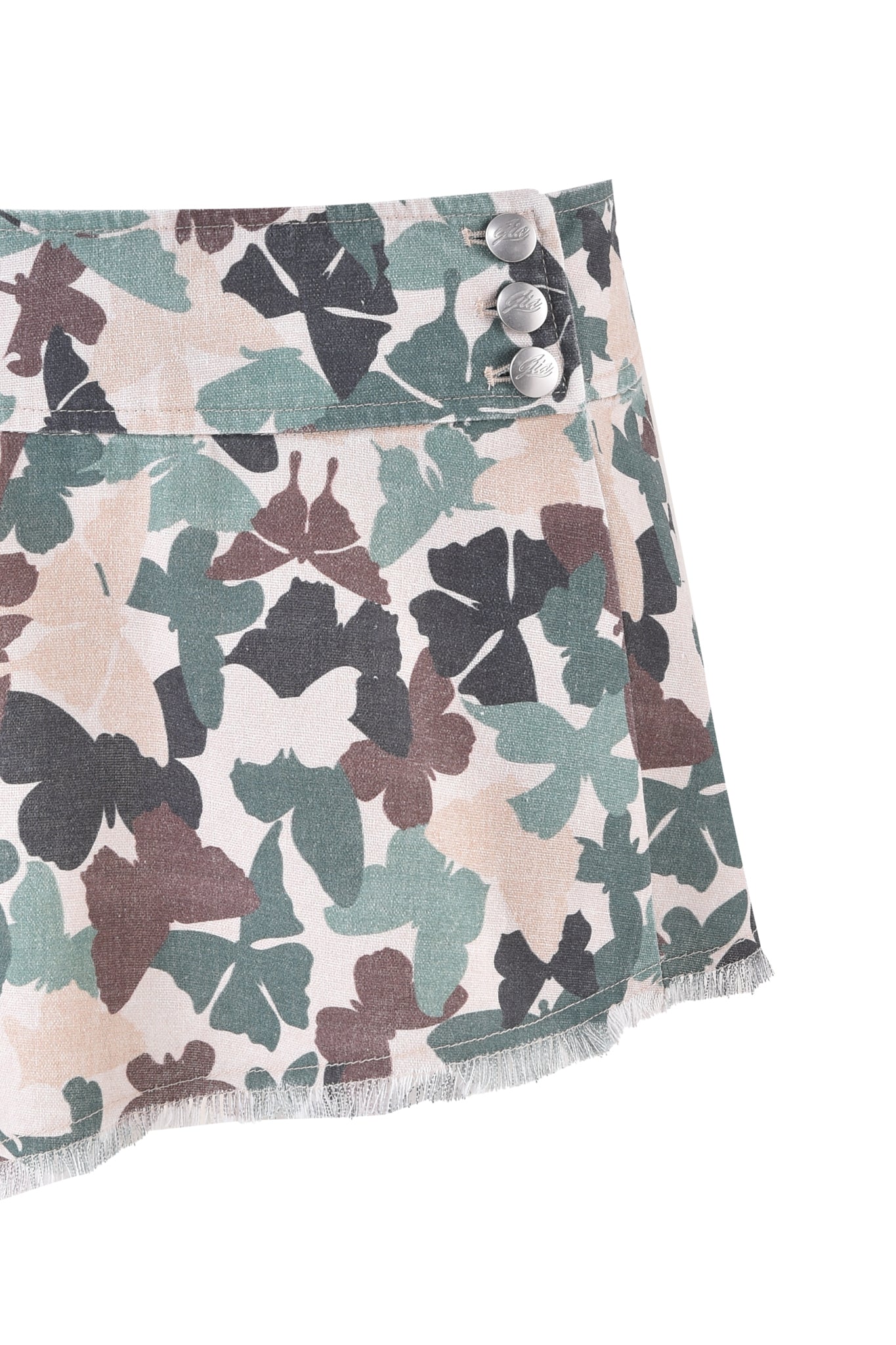 The EFFIE SKIRT - FLUTTER CAMO by I.AM.GIA showcases a close-up of its butterfly camo print with shades of green, brown, and beige. This asymmetrical mini skirt is adorned with three metallic buttons and features a frayed bottom edge.