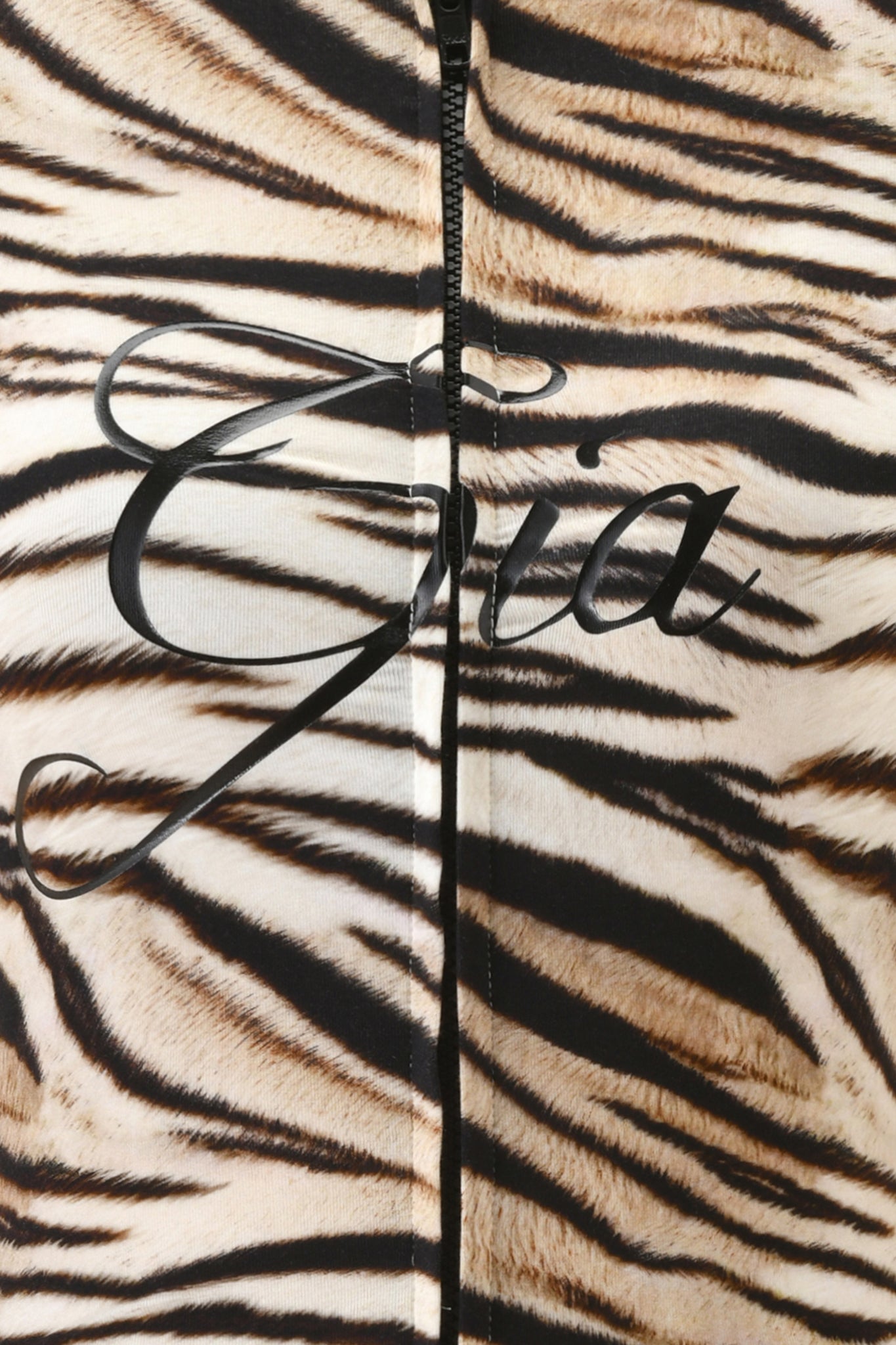 Close-up of the I.AM.GIA BLARE SHORT SLEEVE ROMPER - LIGHT TIGRESS in a bodycon viscose jersey with tiger stripes, a visible black zipper down the middle, and "Gia" in elegant black script across the fabric.