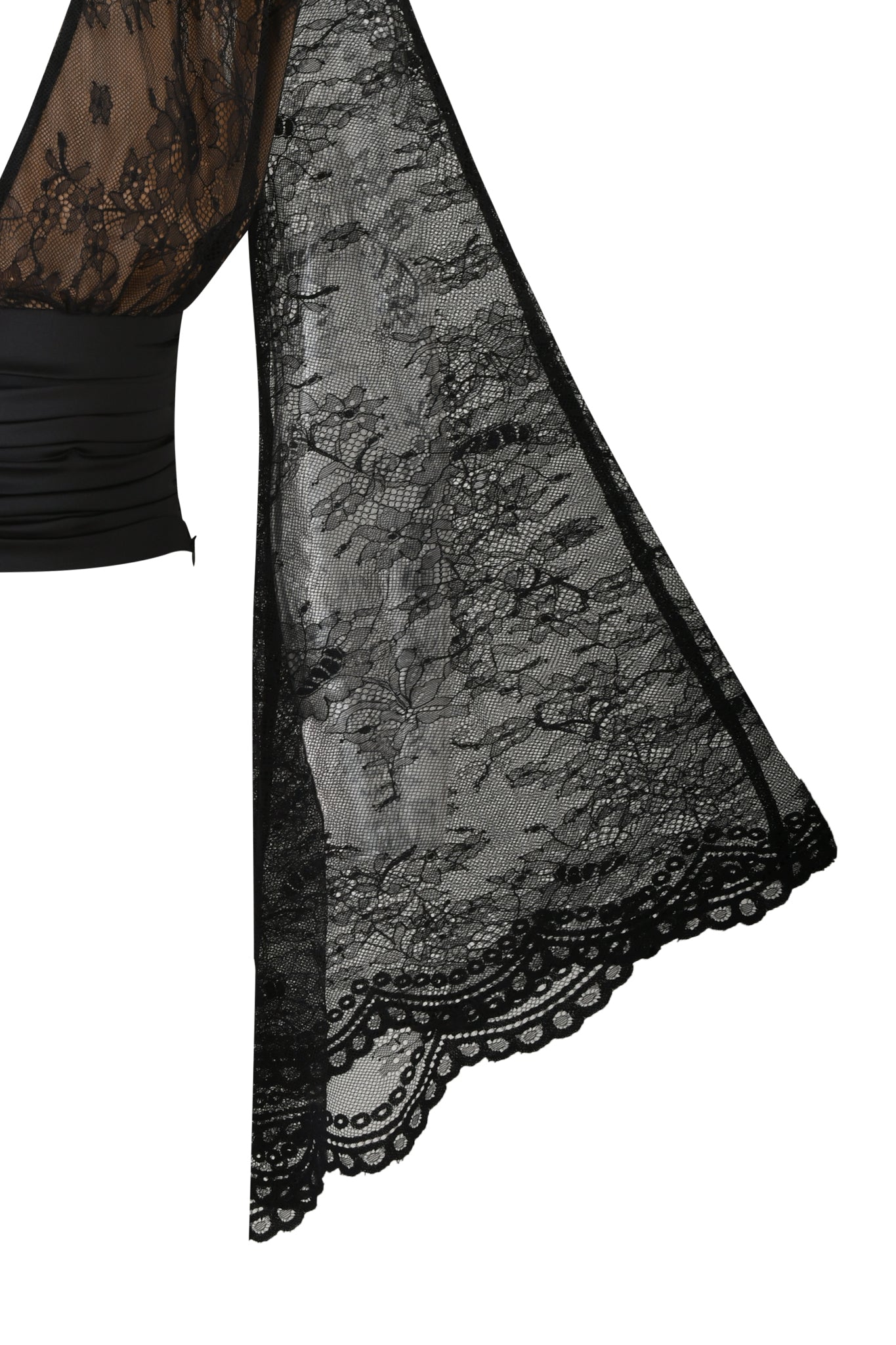 Close-up of the I.AM.GIA STEVIE TOP in black: a sheer floral lace blouse with bell sleeves and flared, scalloped edges, revealing a hint of skin. Set against a plain white background.