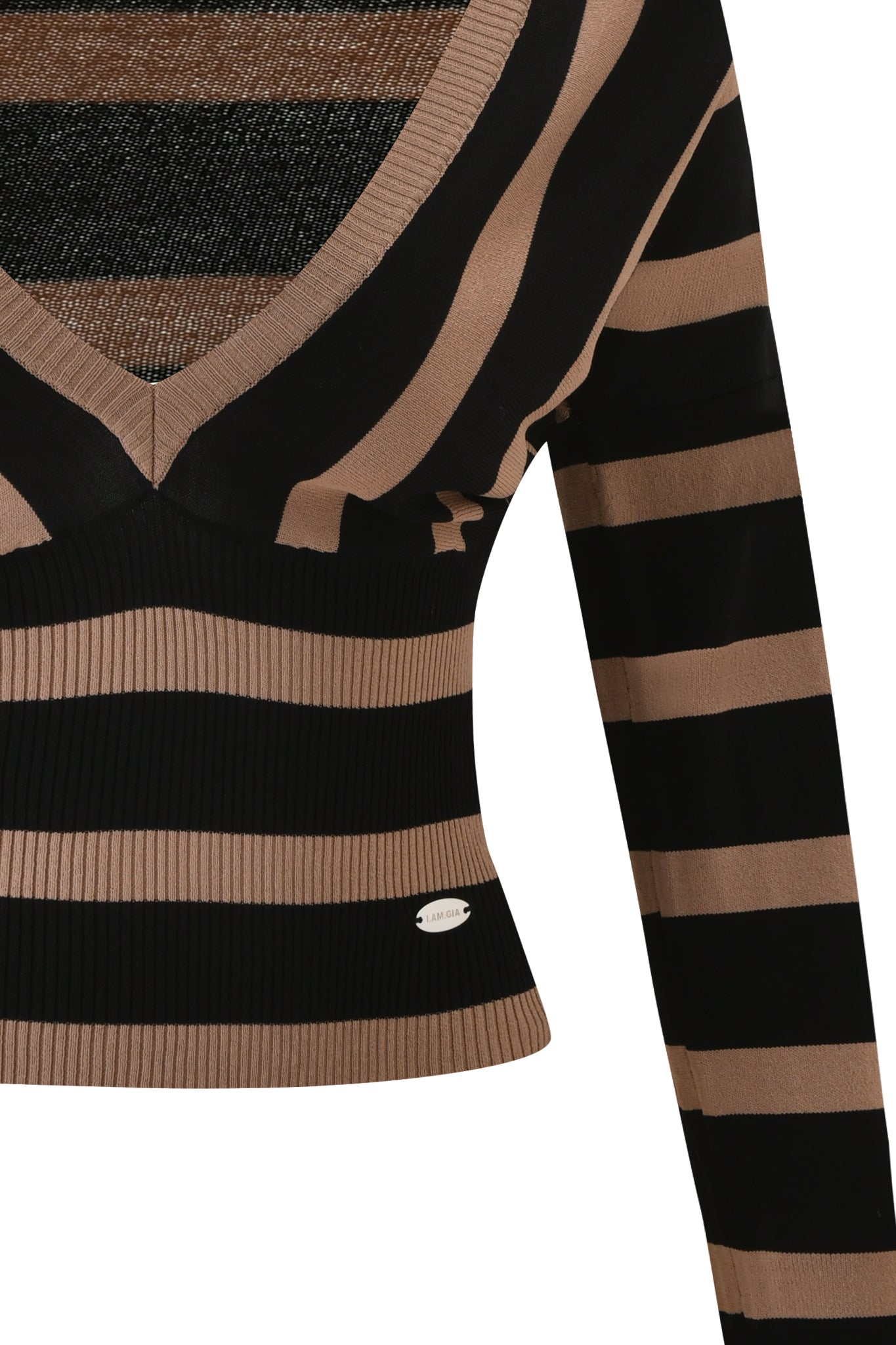 Close-up of the SUZI SWEATER by I.AM.GIA, a long-sleeved V-neck black and tan striped bodycon knit top. Features a ribbed waist and a small oval metallic tag at the bottom hem for a stylish accent.
