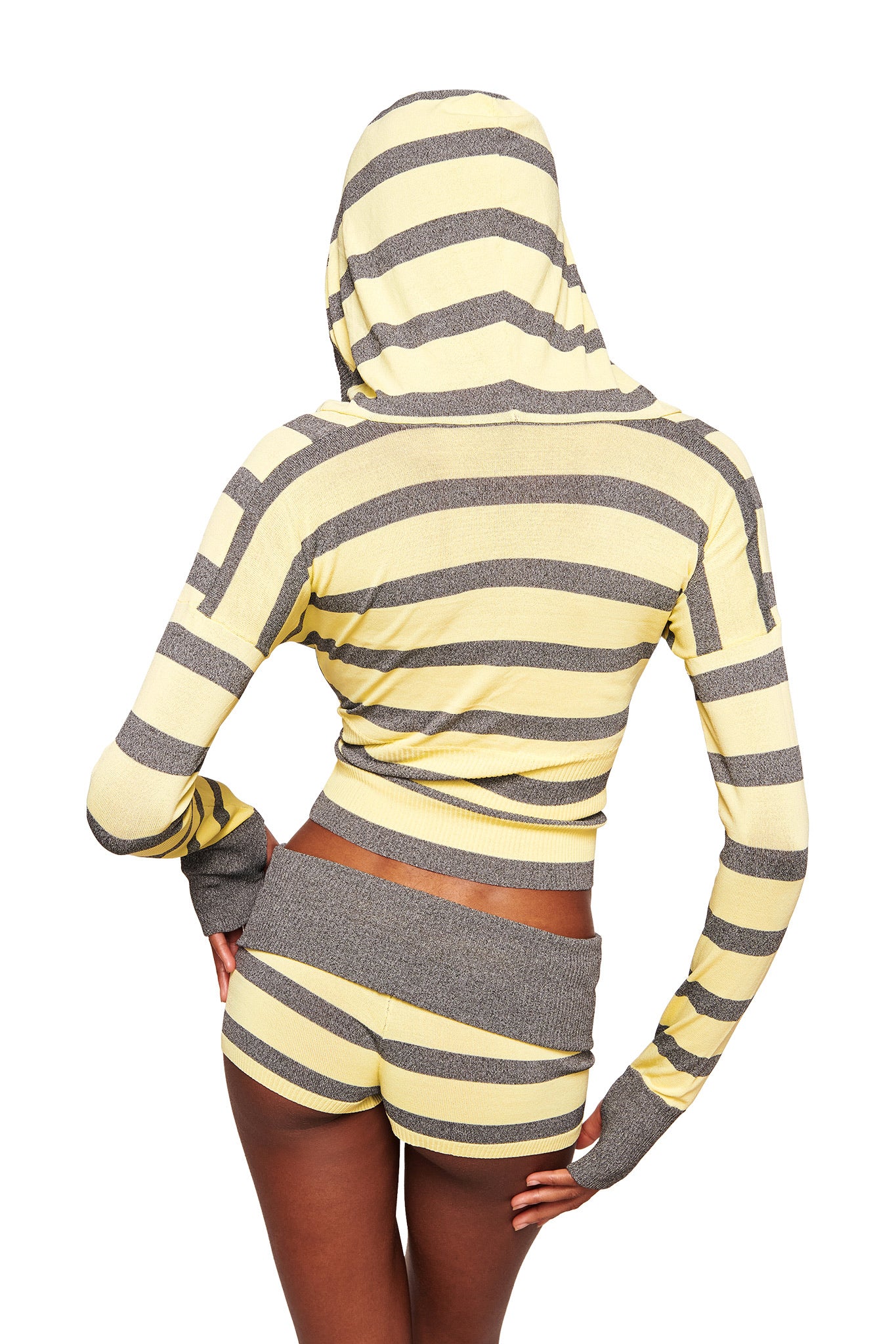 A person faces away from the camera in a yellow and grey striped hooded top and I.AM.GIA SUZI SHORT - YELLOW AND GREY STRIPE, featuring an adjustable waistband and micro mini length, exuding a sporty, fitted look with the hood up.