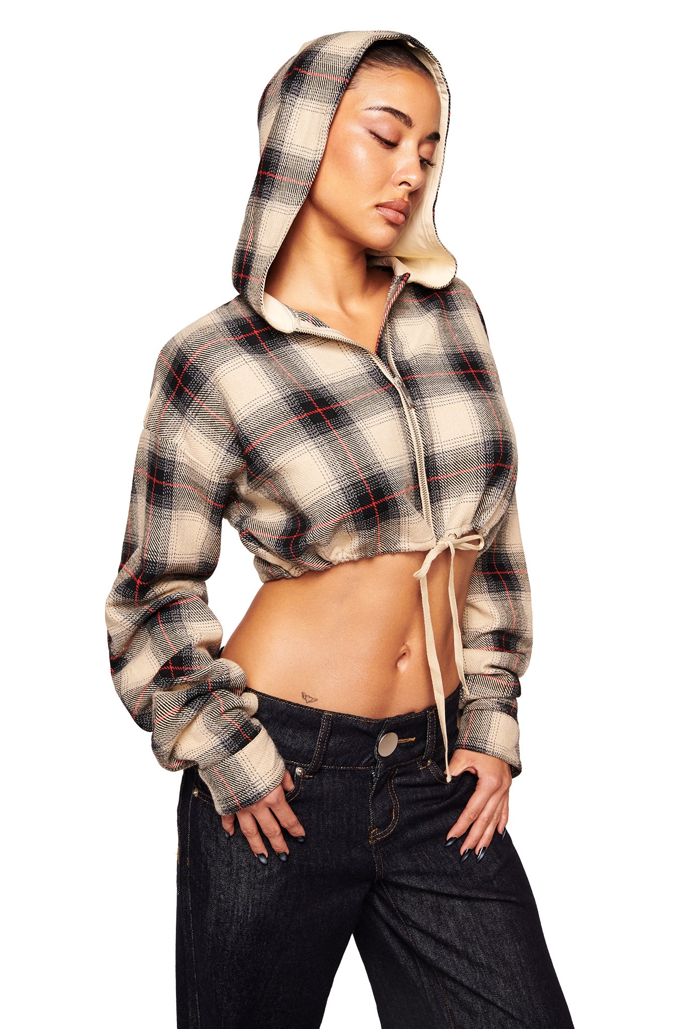 A woman models the I.AM.GIA TIFF JACKET in grey plaid with the hood up, paired with black jeans. She stands against a white background, head tilted and eyes closed, one hand on her hip.