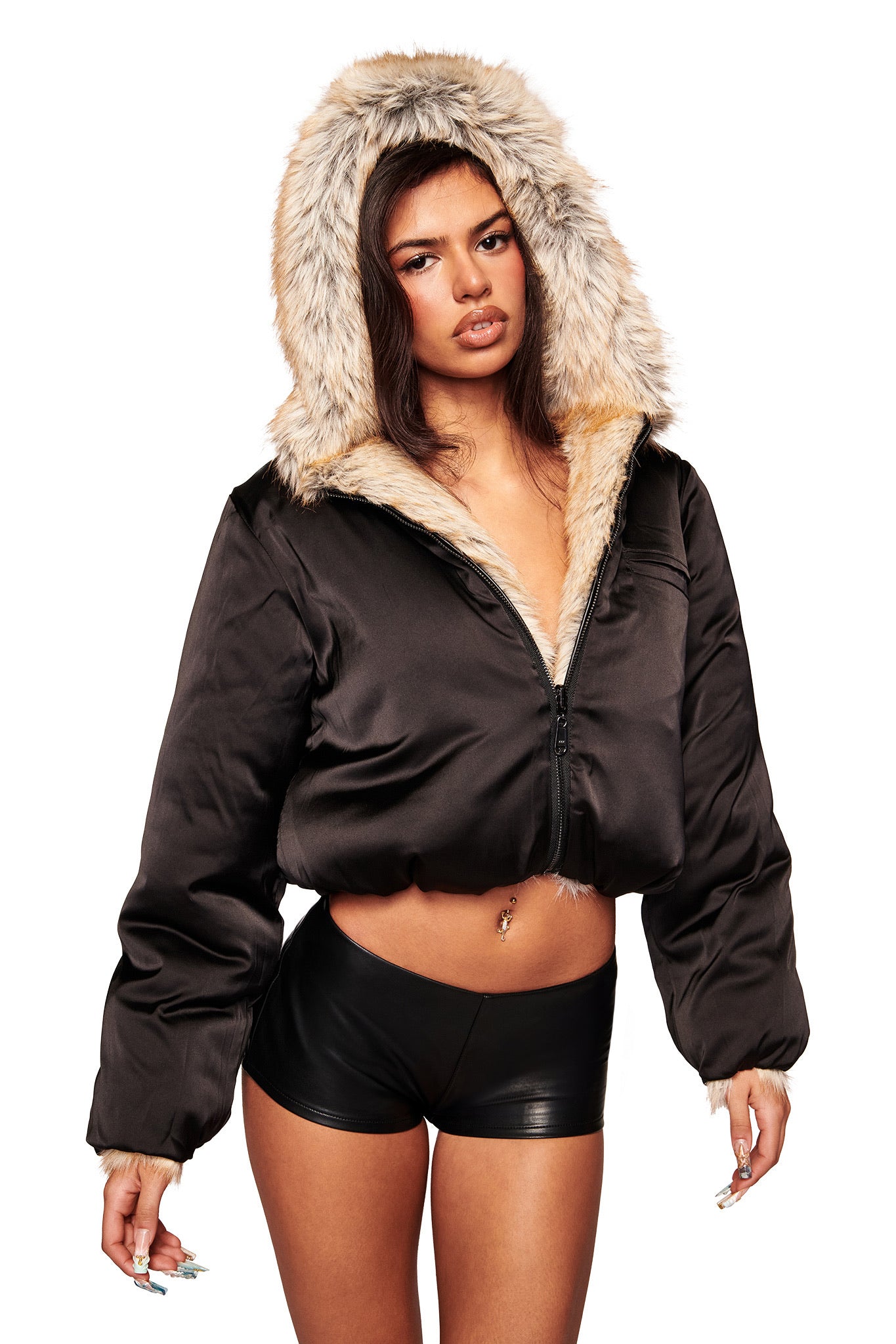 A woman wearing the I.AM.GIA EVEREST REVERSIBLE JACKET in brown and black high-waisted shorts poses against a white background.